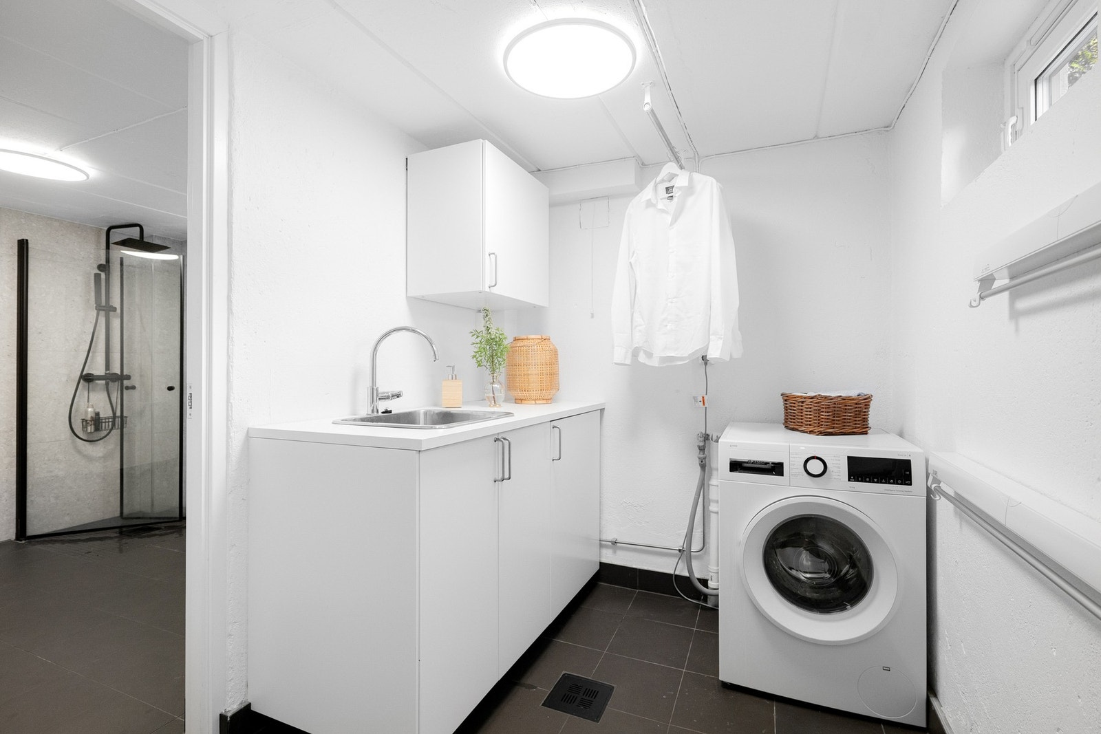 Lyst og praktisk vaskerom fra 2022 med flislagt gulv og elektriske varmekabler. Galleribilde