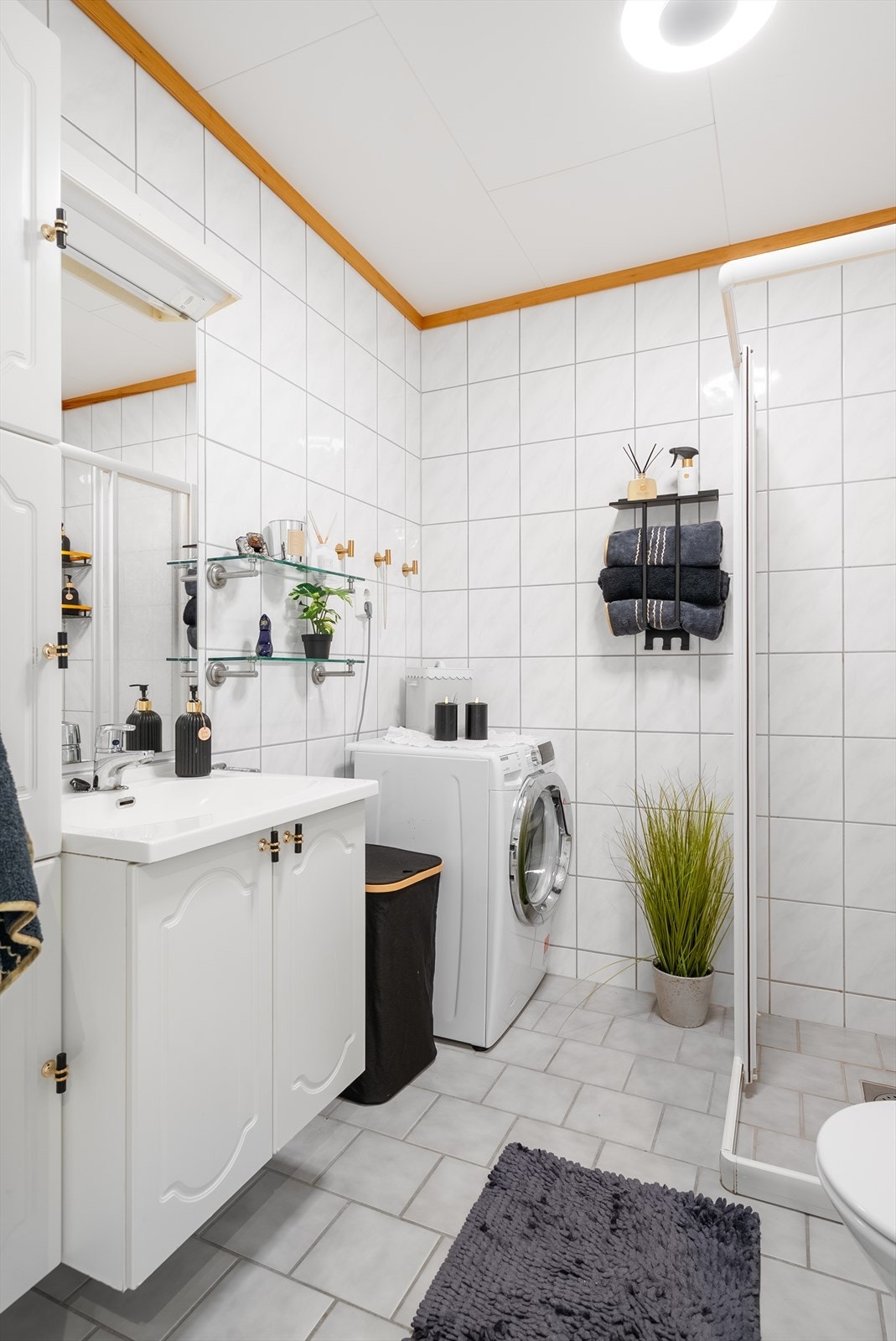 Badet er innredet med dusjhjørne, klosett, servant i baderomsinnredning samt opplegg for vaskemaskin. Det er for øvrig mekanisk avtrekk. Galleribilde