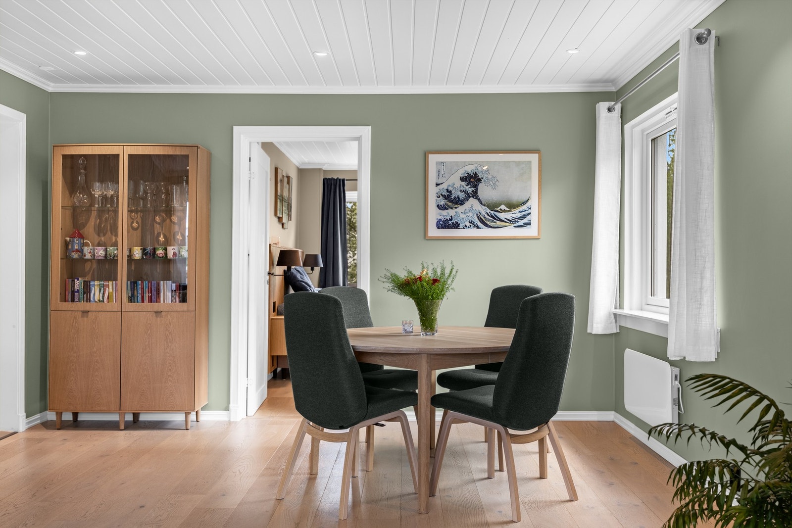 Stuen har pent, enstavs parkettgulv, glatte veggflater i en delikat grønnfarge og hvitmalt panelhimling med downlights. Galleribilde