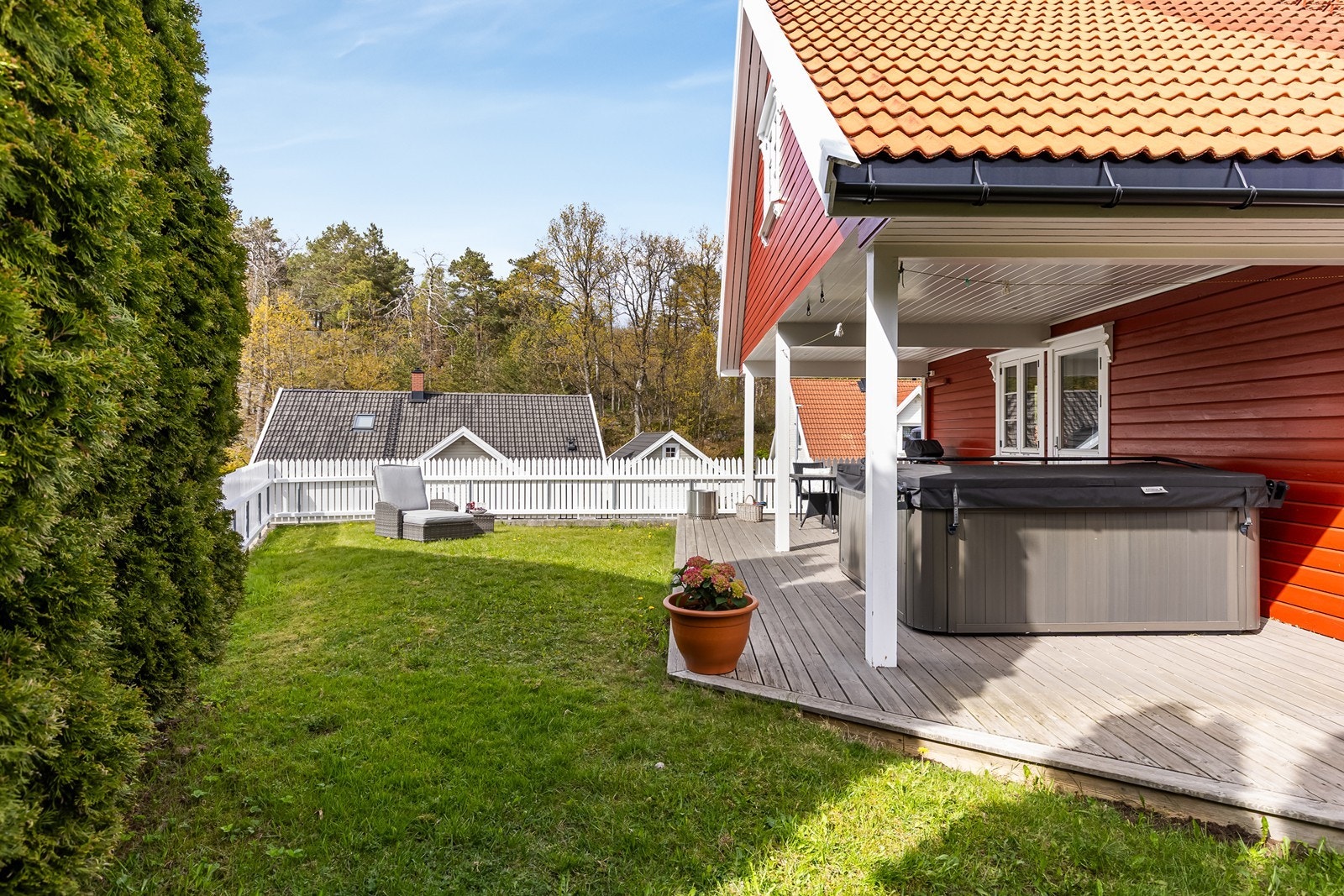Tomten er pent opparbeidet med lettstelt hage og terrasse med utgang fra stuen Galleribilde