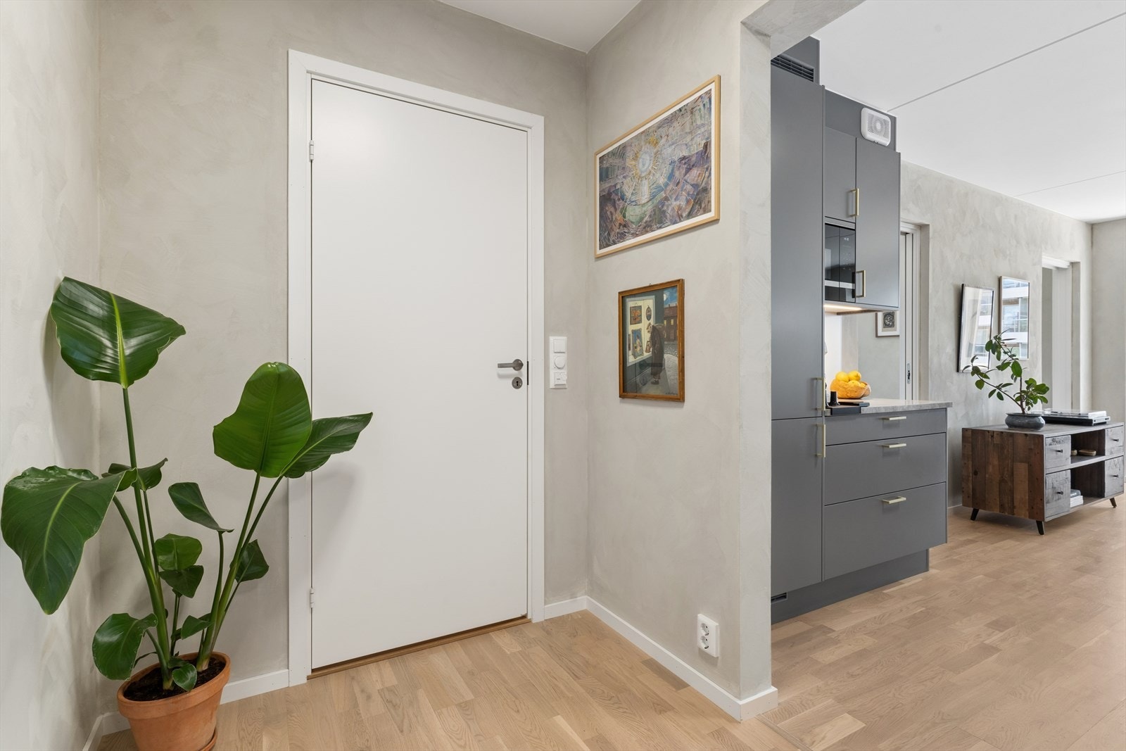 Entréen gir umiddelbare tilgang til kjøkkenet og baderommet og er innredet med skyvedørsgarderobe for enkel oppbevaring Galleribilde