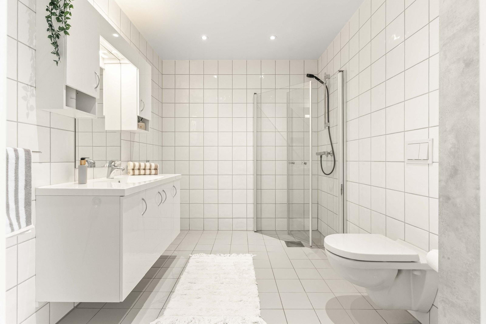 Badet i andre etasje har flislagte overflater, gulvvarme, vegghengt toalett og downlights i taket. Galleribilde