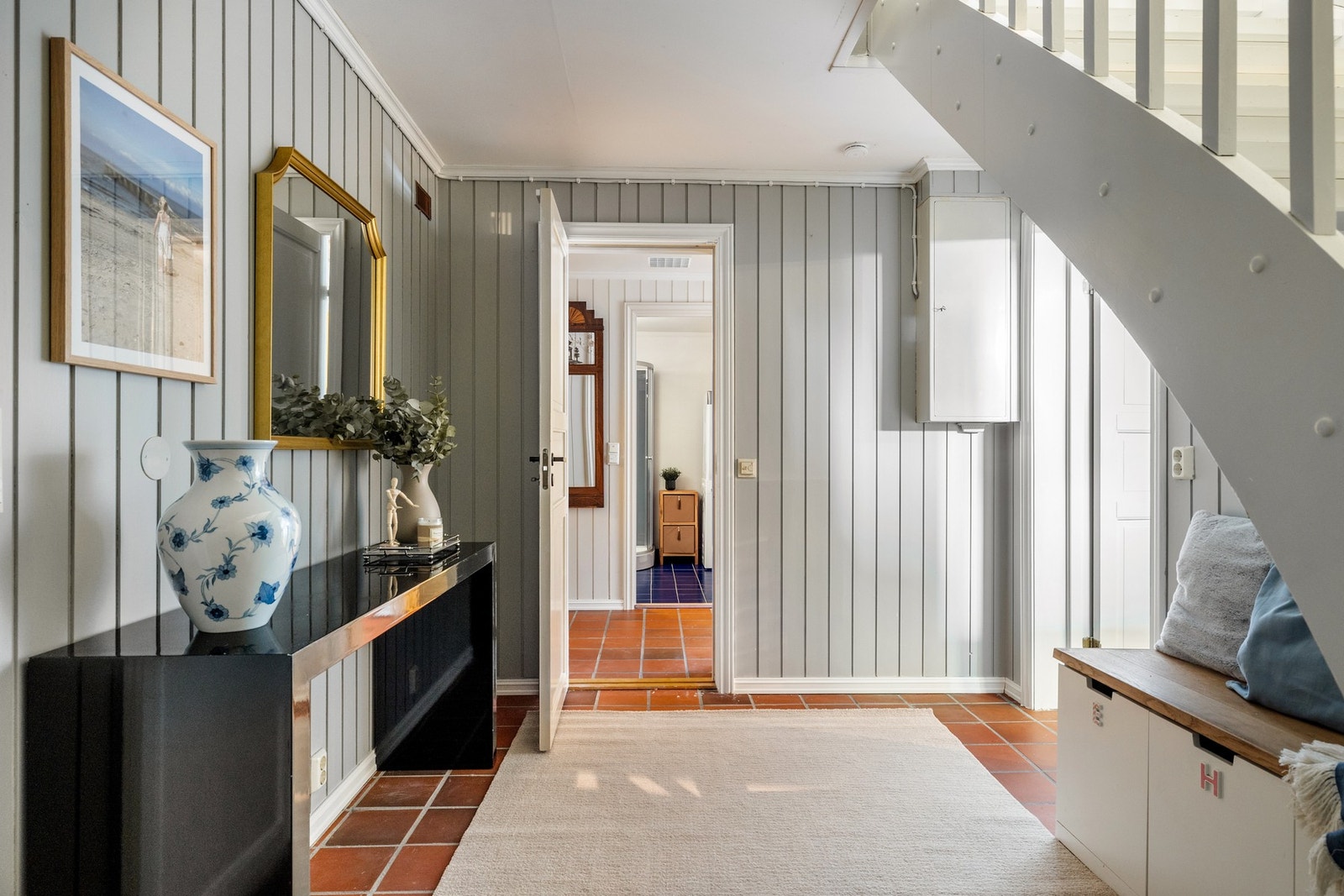 Trapperom i underetasje med inngang til vaskerom, Rom innredet med treningsutstyr og sofa samt separat del i underetasjen. Galleribilde