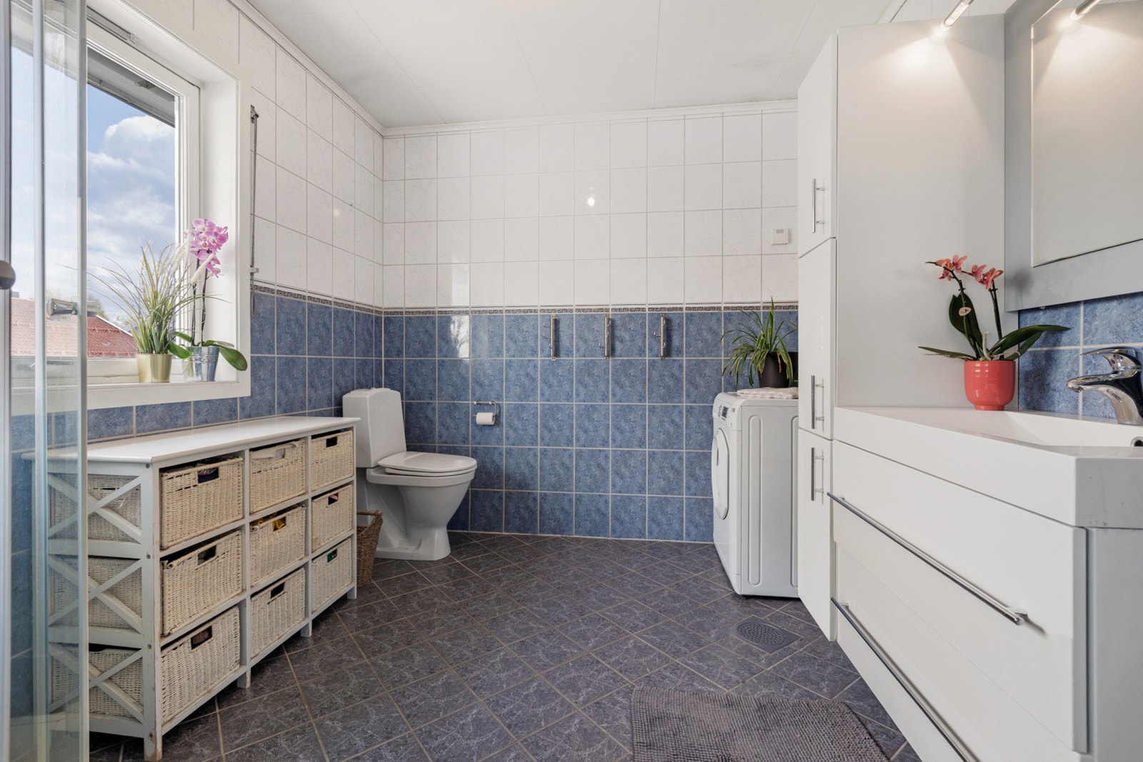 Badet er romslig og har flislagte vegger og gulv. Baderomsinnredningen har to skuffer og heldekkende servantplate. Galleribilde