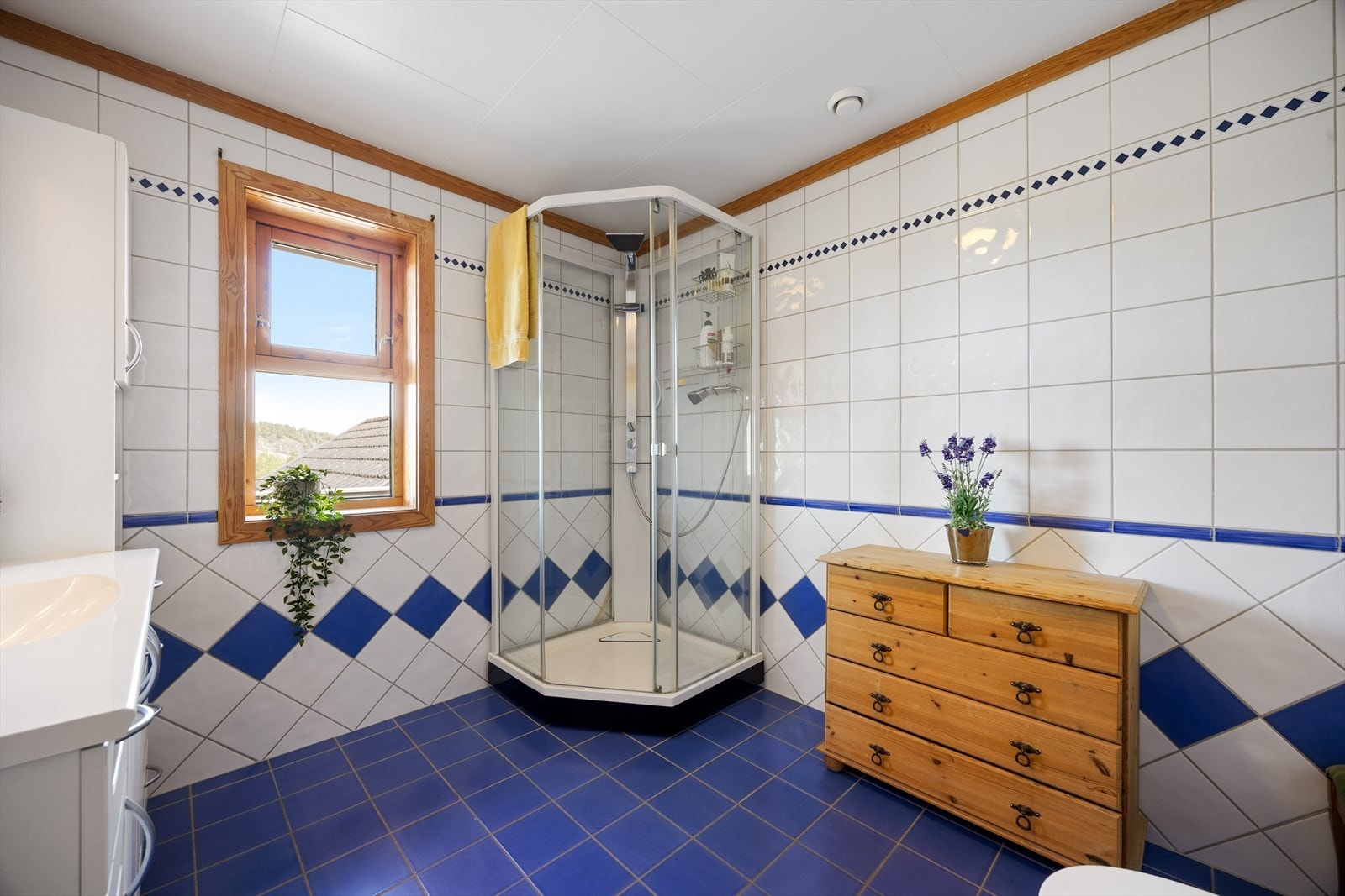 Badet i hovedetasje har flislagt gulv med varmekabler og dusjkabinett. Galleribilde