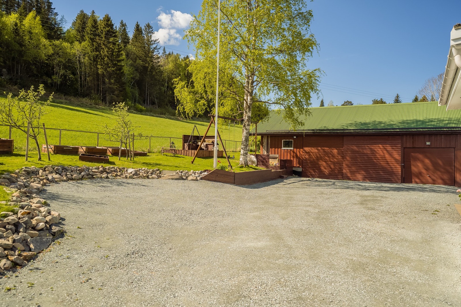 Svært stor gårdsplass med plass til flere biler. Det er installert elbillader. Uthus/garasje på 86 kvm. Galleribilde