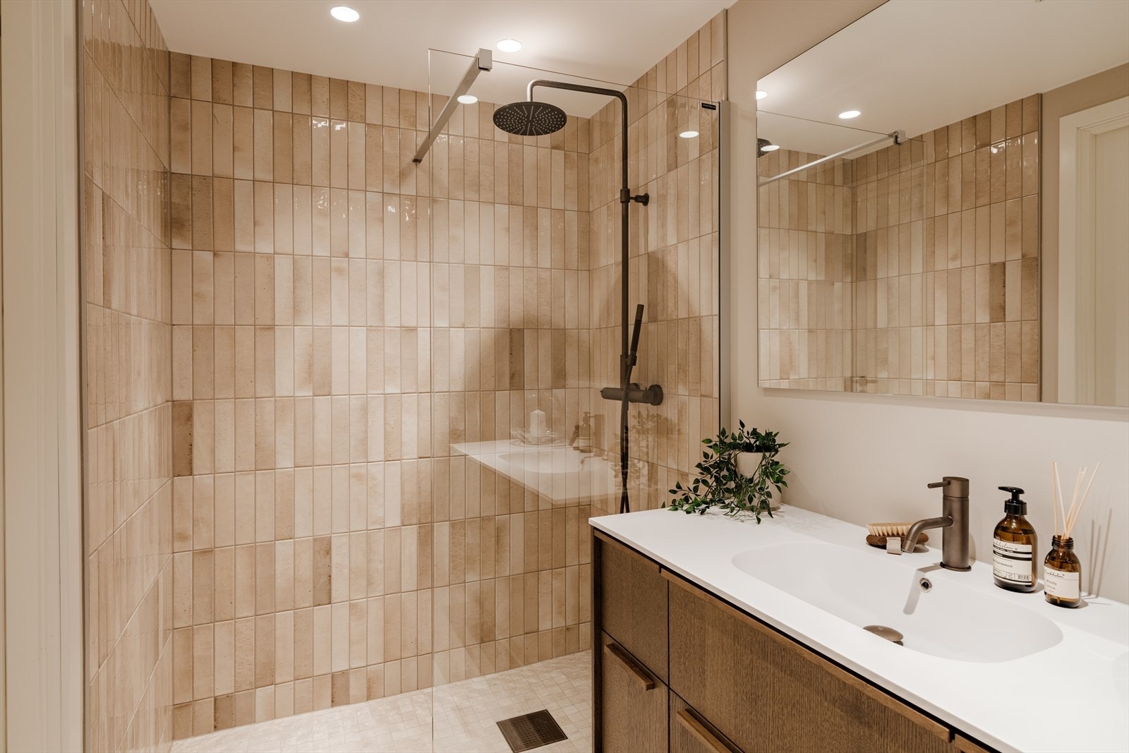 Også dette badet har baderomsmøbler fra HTH, som spiller godt sammen med de lyse beige fliser. Heldekkende servant og ettgreps servantbatteri i bronze fra Tapwell. Galleribilde