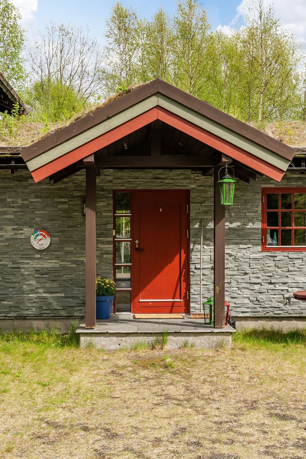 Det fine og overbygde inngangspartiet er på den tilbygde delen av hytta, og har fasadeskifer på vegg. Galleribilde