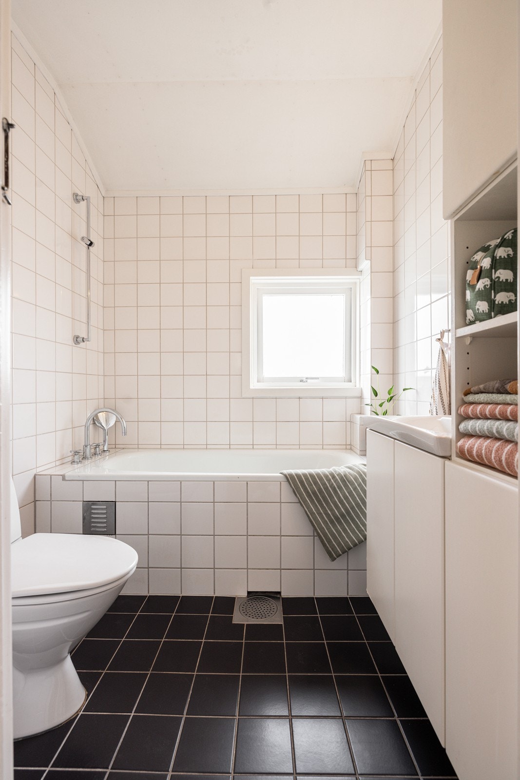 Lyst bad med wc, servant i diverse innredning og dusj i innmurt badekar. Galleribilde