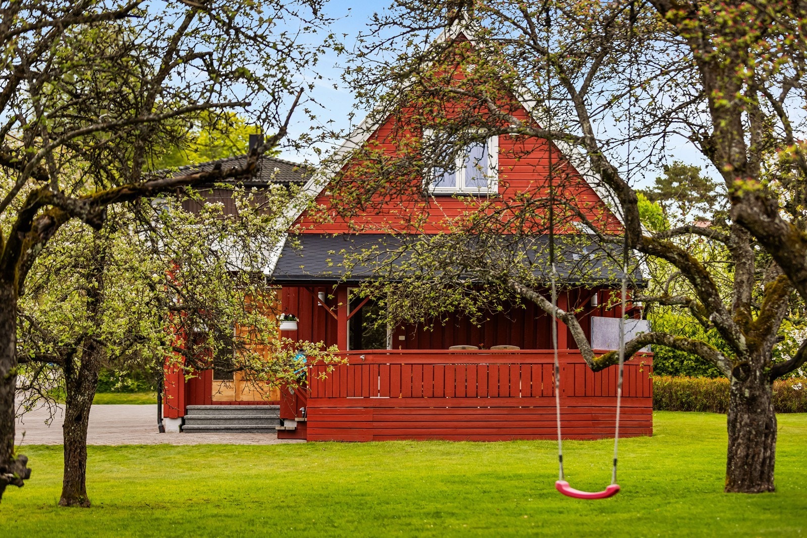 Fra hagen ser man mot den delvis overbygde terrassen med utgang fra kjøkkenet. Galleribilde