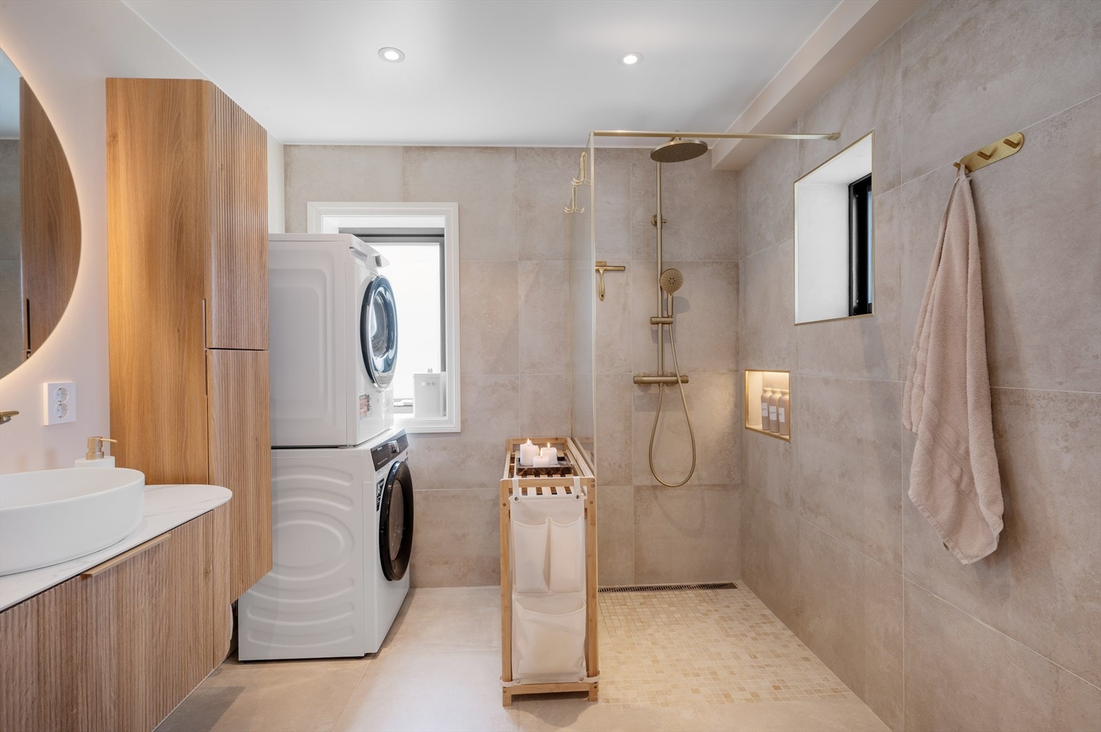 Badet er utstyrt med servantinnredning, høyskap, vegghengt toalett, dusjvegg og opplegg for vaskemaskin. Galleribilde