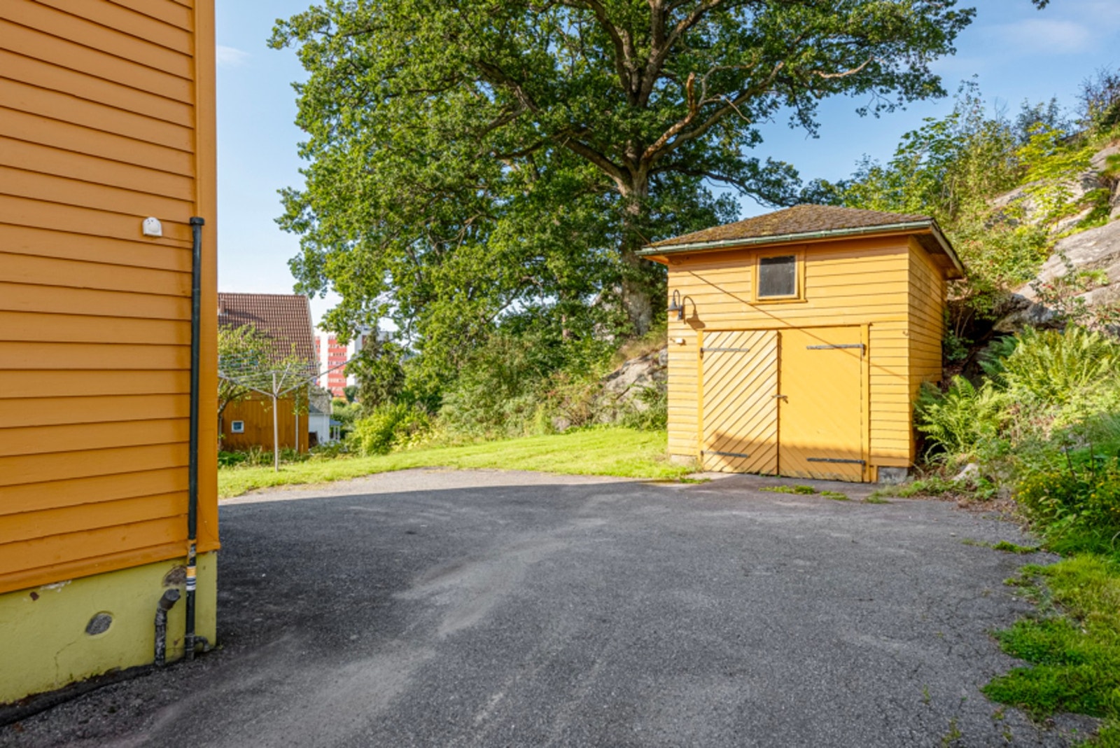Enkel garasje i treverk med loftsrom. Plassbygget sidehengslet 2 fløyet garasjeport Galleribilde