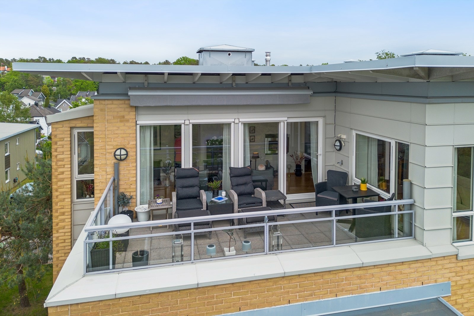 Fra stuen er det utgang til en romslig takterrasse på 14 m² med motorisert markise og glassrekkverk. Galleribilde