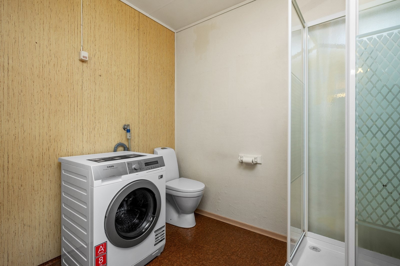 Badet er utstyrt med dusjkabinett, vaskemaskin, toalett og servant. Galleribilde