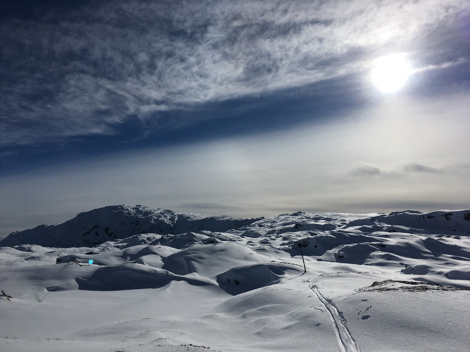 Freden senker seg med ski på bena i fjellet rett ovenfor hytten. Galleribilde