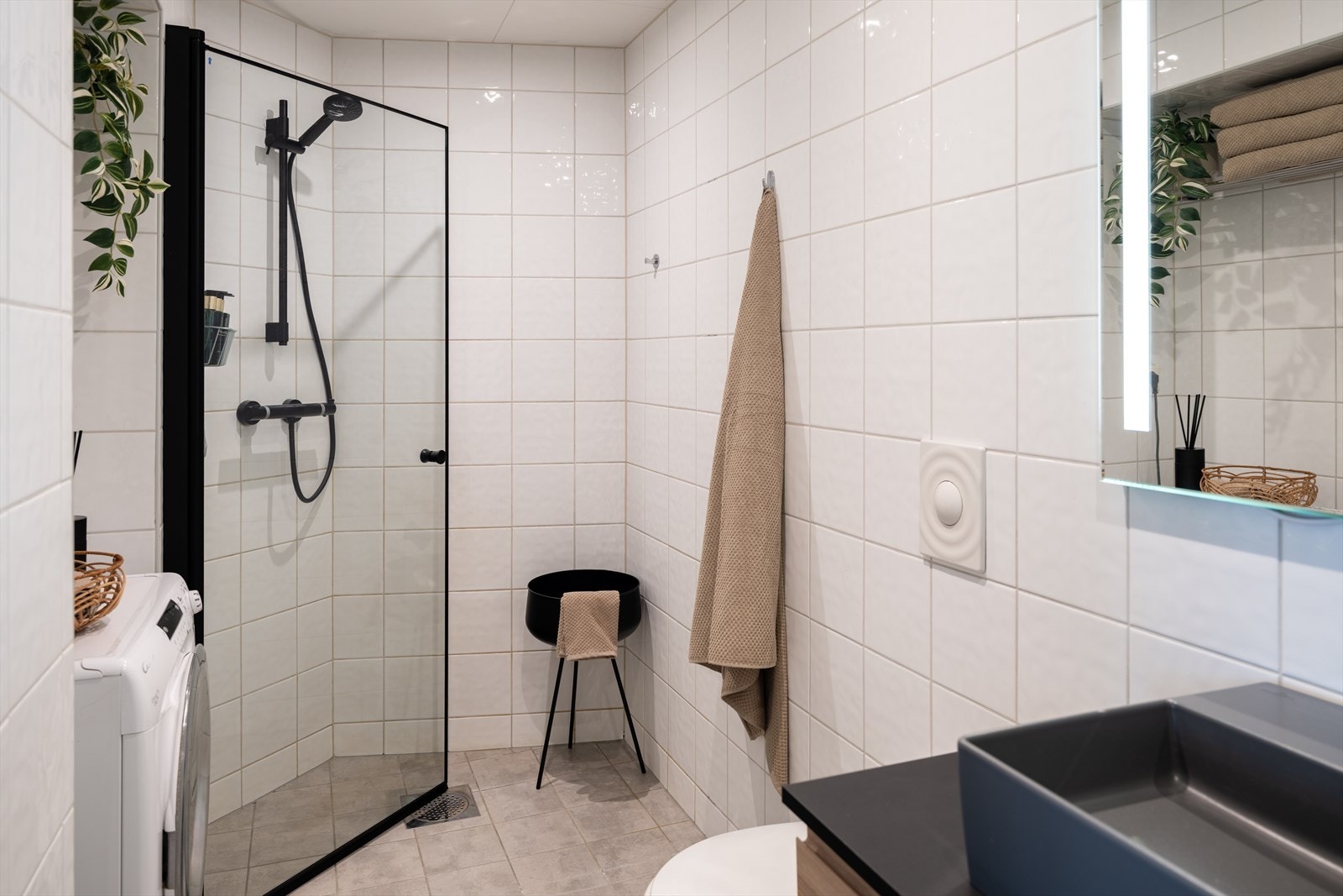 Videre byr badet på dusj med innfellbare dusjdører, vegghengt toalett og opplegg for vaskemaskin. Oppgradert i 2012. Galleribilde