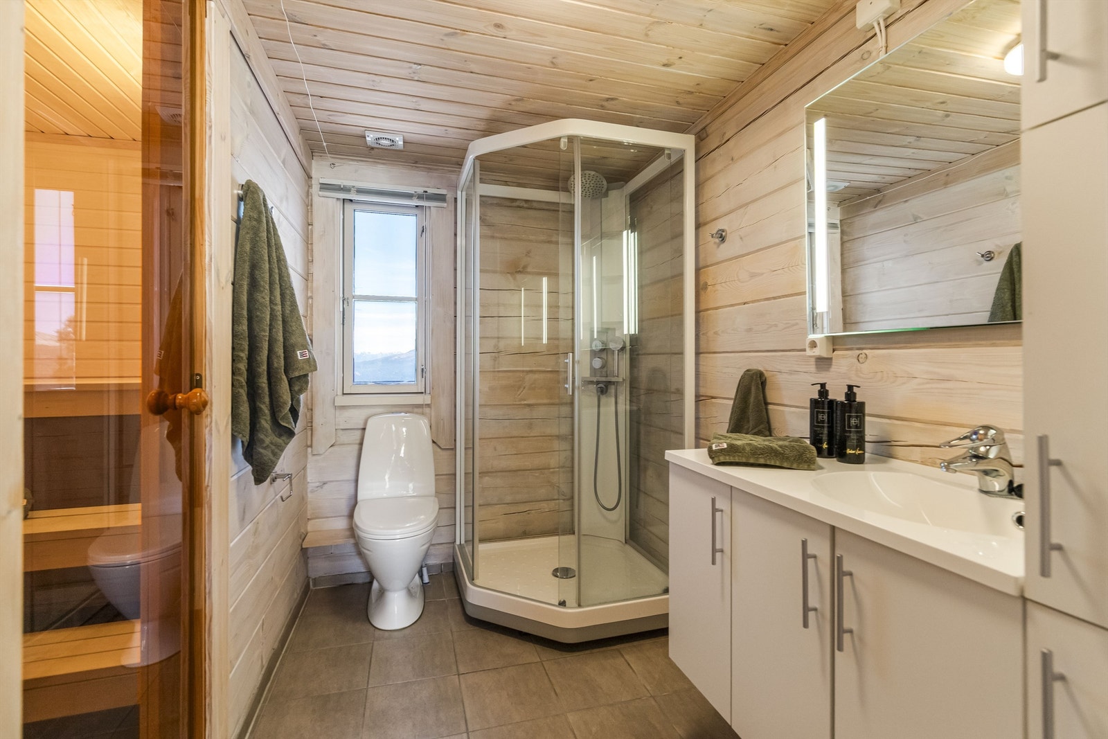 Badet i første etasje har flislagt gulv med gulvvarme, dusjkabinett og direkte tilgang til badstuen. Galleribilde