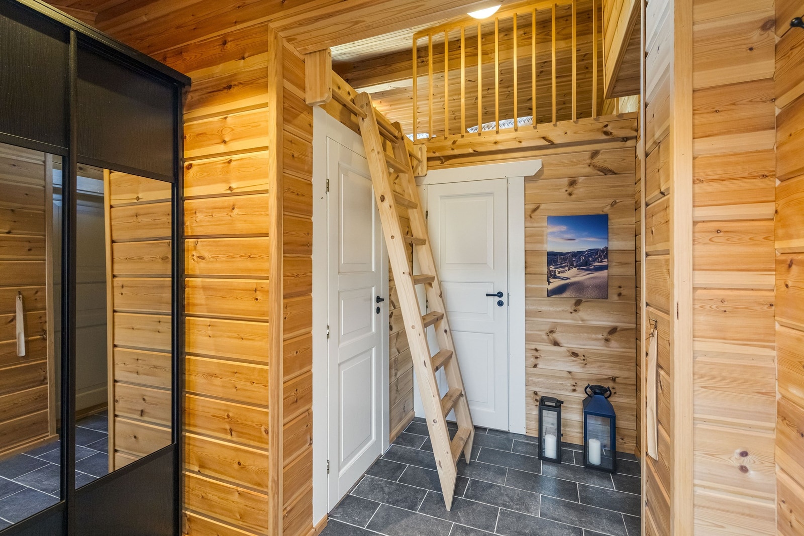 Entréen har flislagt gulv med gulvvarme og en romslig skyvedørsgarderobe for yttertøy. Stigen til hemsen er fleksibel og settes enkelt opp for bruk. Galleribilde