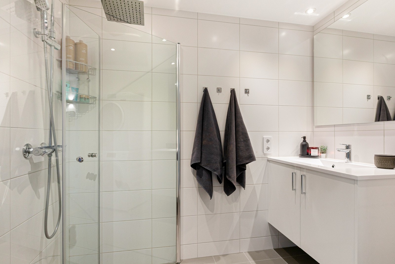 Badet er innredet med dusjnisje med innfellbare glassdører, servantinnredning med speil samt vegghengt toalett. Galleribilde