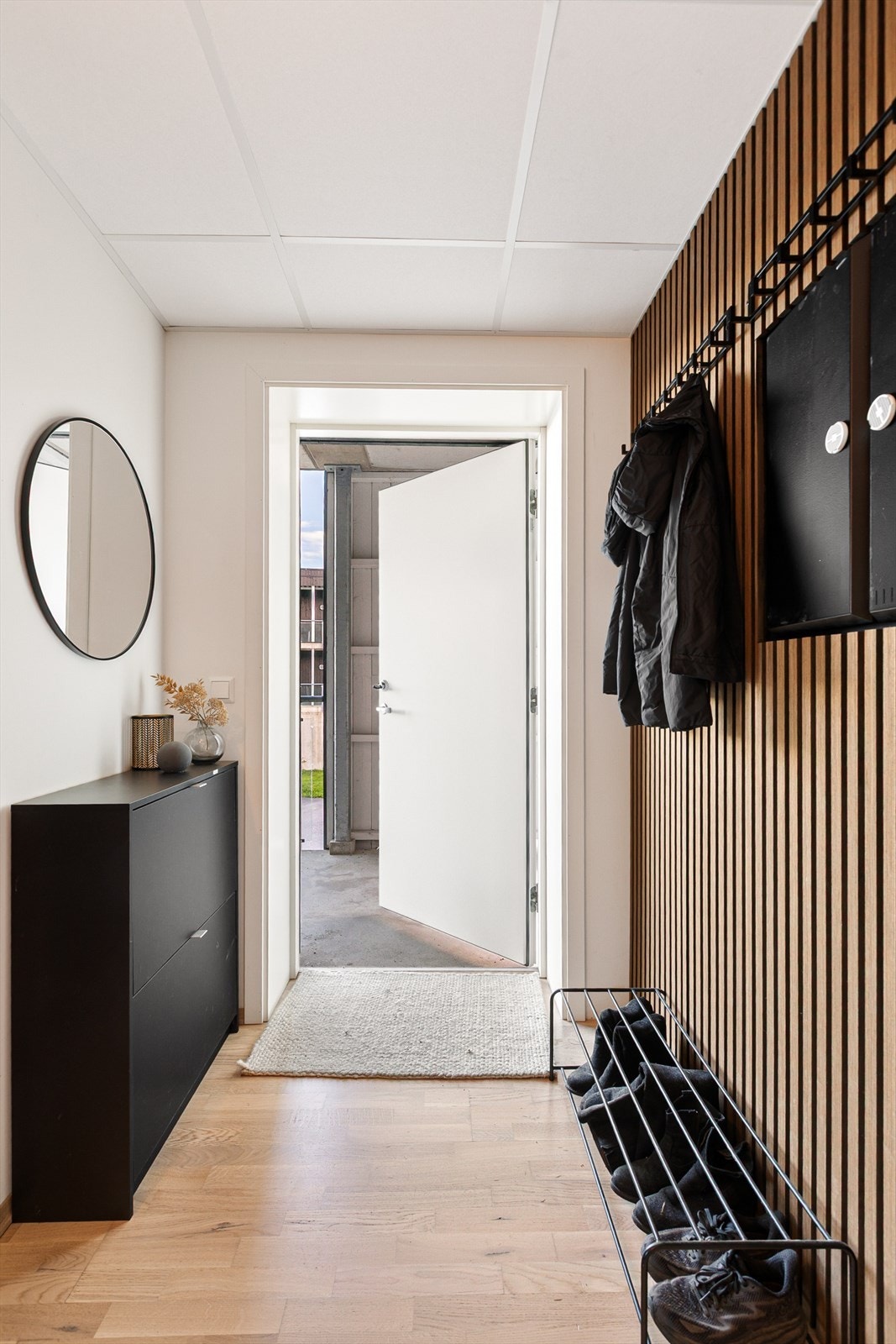 Velkommen inn i en delikat og innbydende entré. Rommet er oppgradert med moderne detaljer, blant annet en stilren spilevegg med tilhørende knaggrekke. Galleribilde