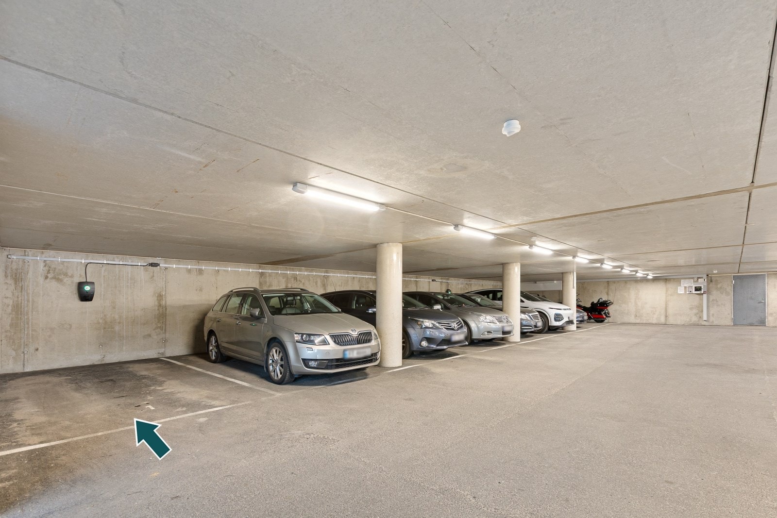 Det medfølger en parkeringsplass i carport/garasjeanlegg under bygget, med installert elbil-lader. Galleribilde