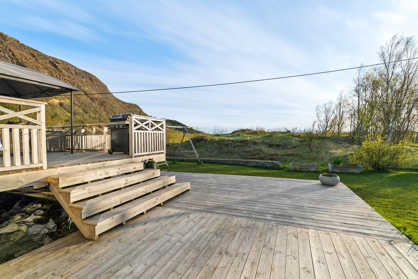 En bred trapp forbinder balkongen med hagearealet. Galleribilde