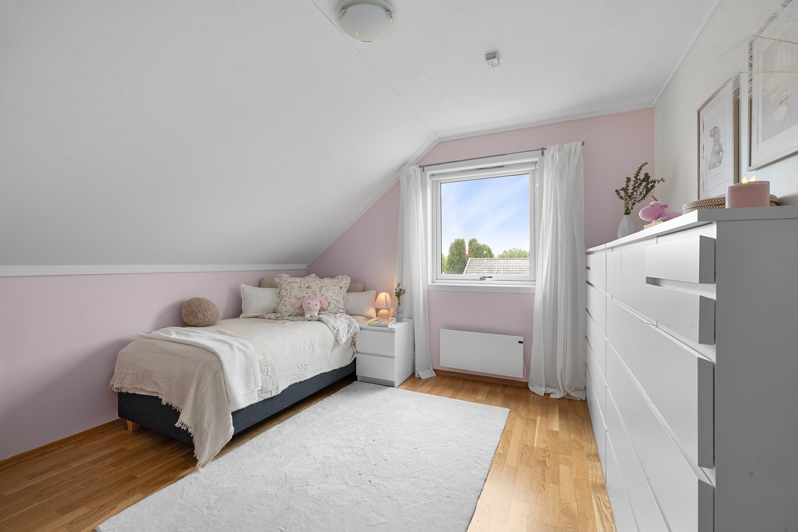 Det ene barnerommet er malt i en delikat, lys rosa farge, mens det andre er holdt i den samme lune beigetonen som hovedsoverommet, begge med skråtak som gir en koselig karakter. Galleribilde