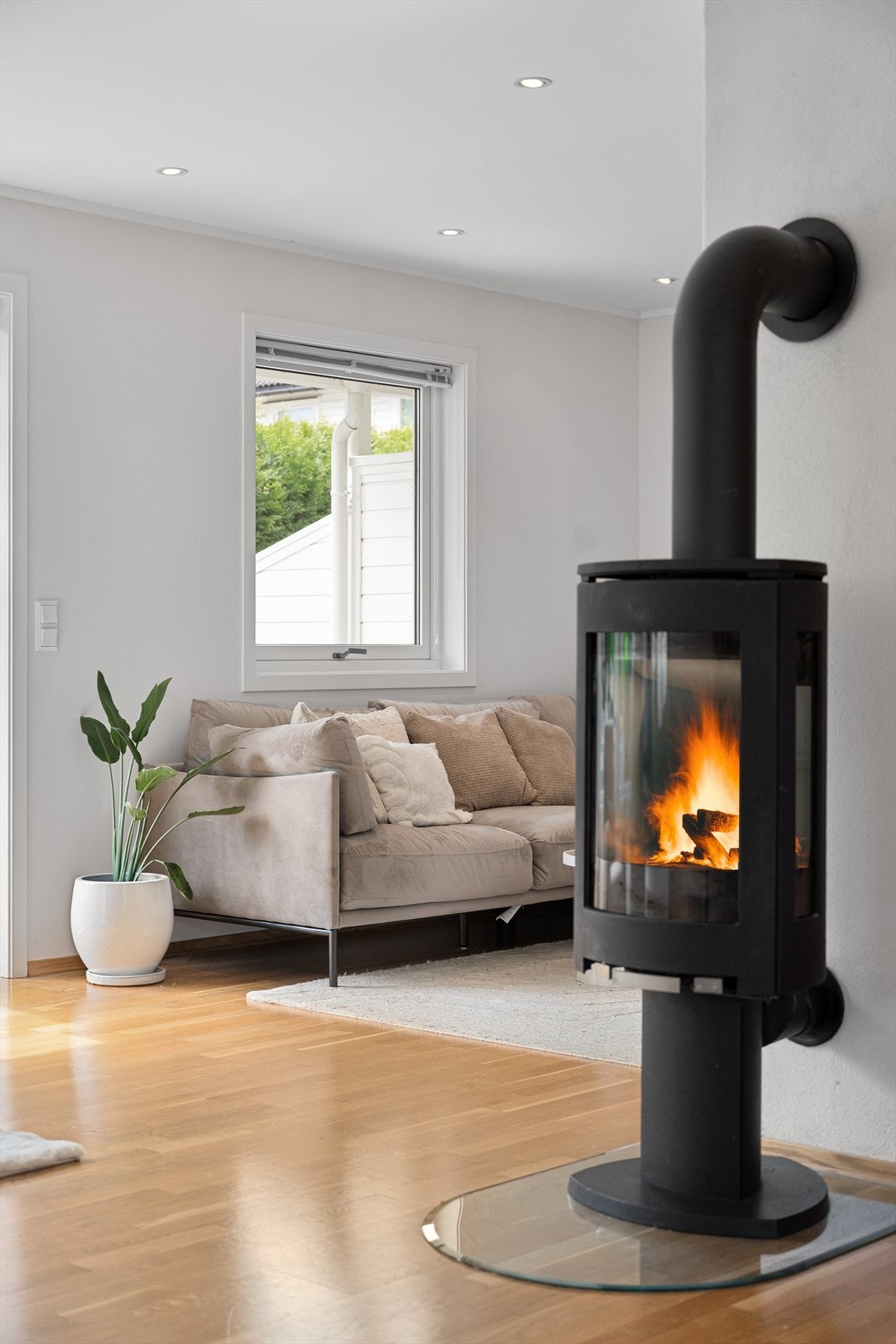 En moderne og stilren peisovn er sentralt plassert og sørger for både lun varme og ekstra hygge på kjøligere dager. Galleribilde