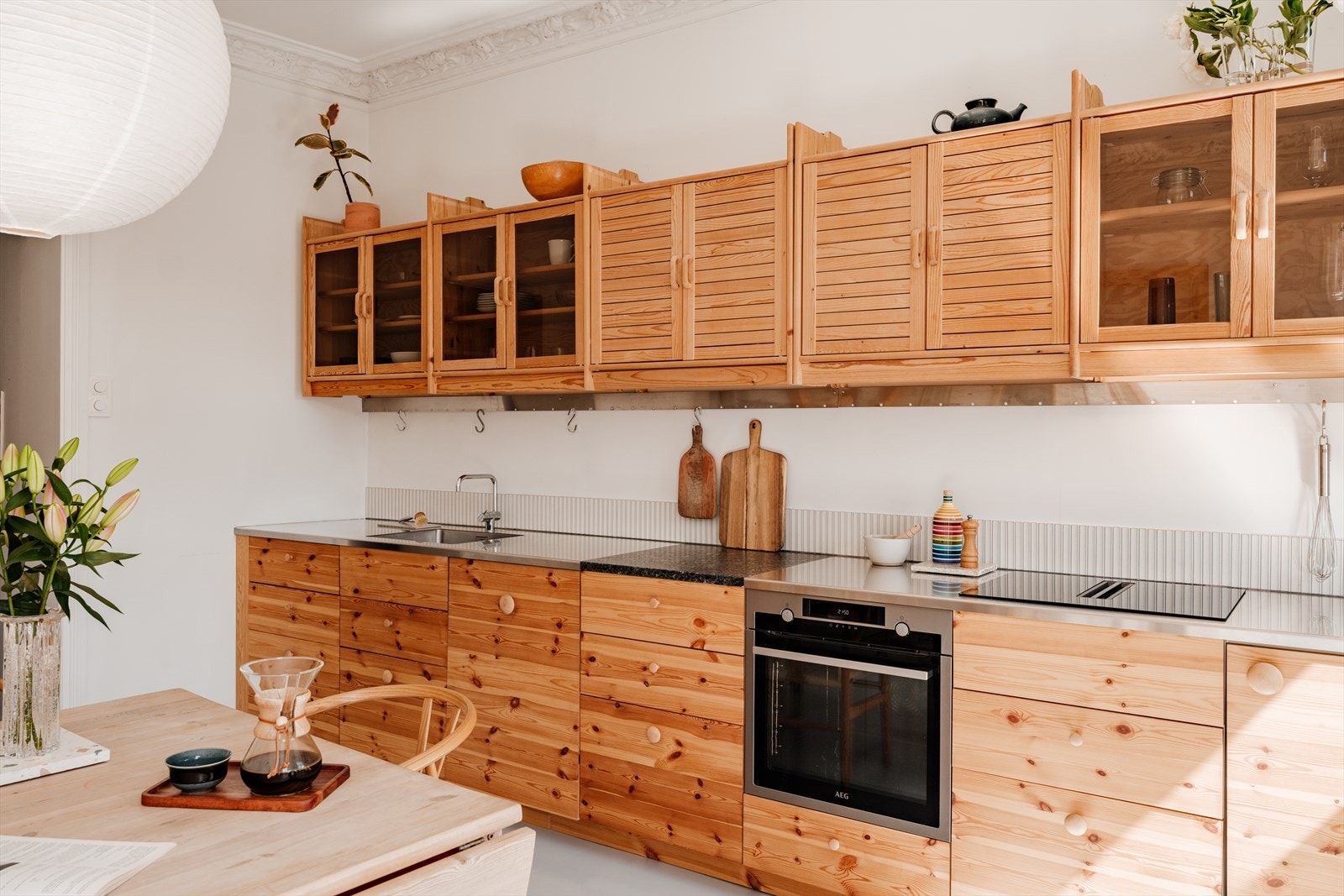Moderne IKEA-kjøkken fra 2024 med egenkomponerte fronter, overskap fra BBB Reoler og lekker benkeplate i stein. Galleribilde