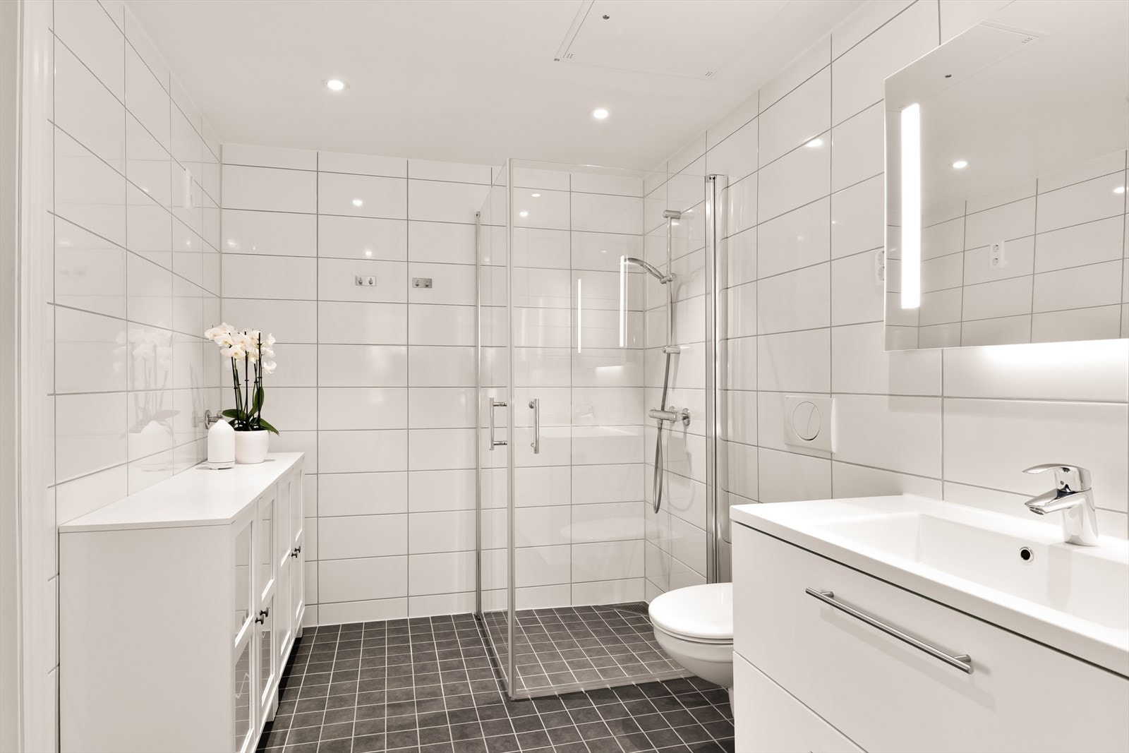 Badene fremstår moderne, stilrene og svært innbydende med tidsriktige materialvalg og en elegant helhet som understreker leilighetens høye standard. Galleribilde