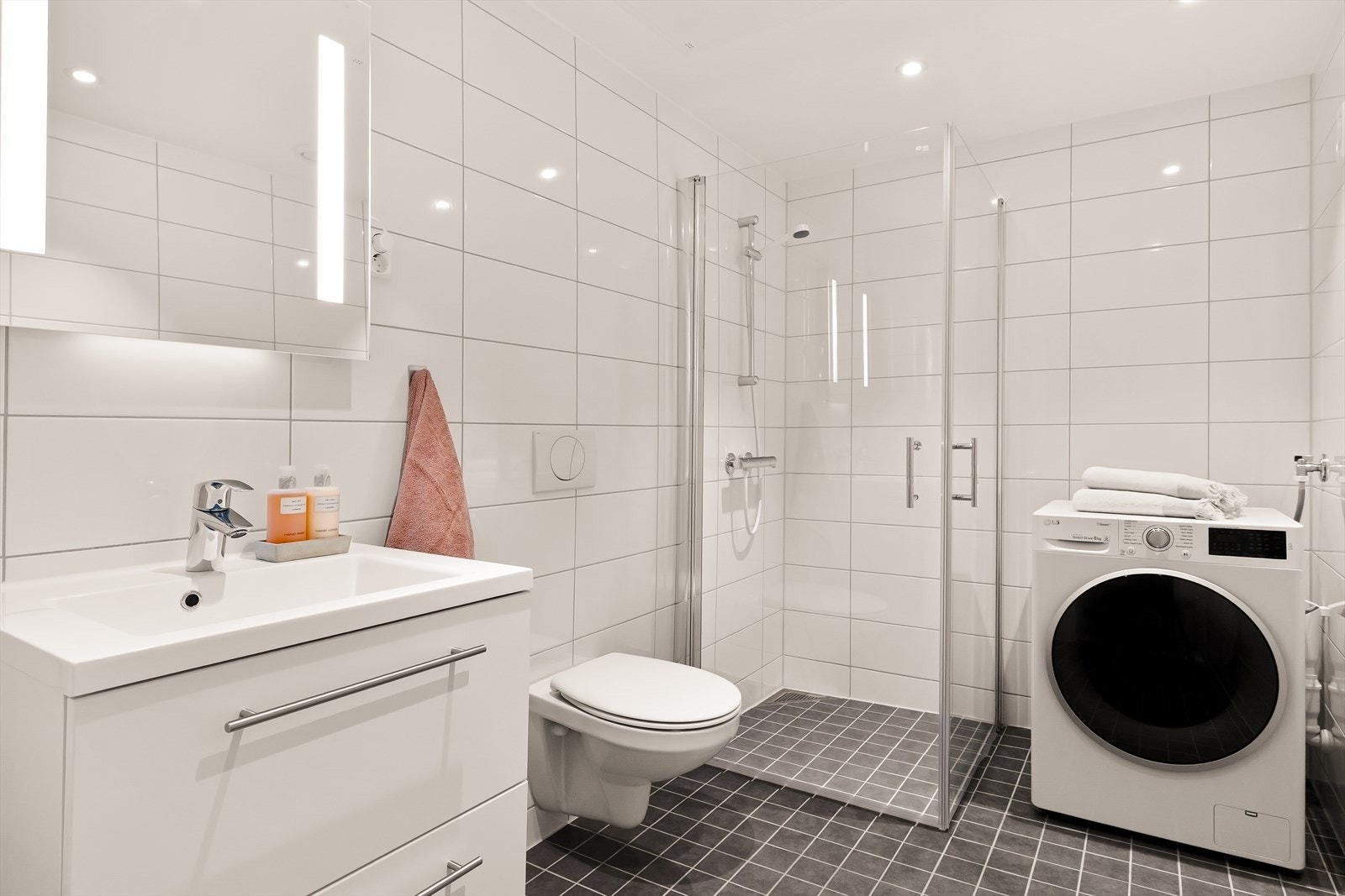 Leiligheten har et lyst og delikat gjestebad med moderne og stilrent uttrykk. Badet fremstår elegant med flislagte overflater i tidløse toner, downlights i himlingen og behagelige varmekabler i gulvet som gir en komfortabel og eksklusiv atmosfære. Galleribilde