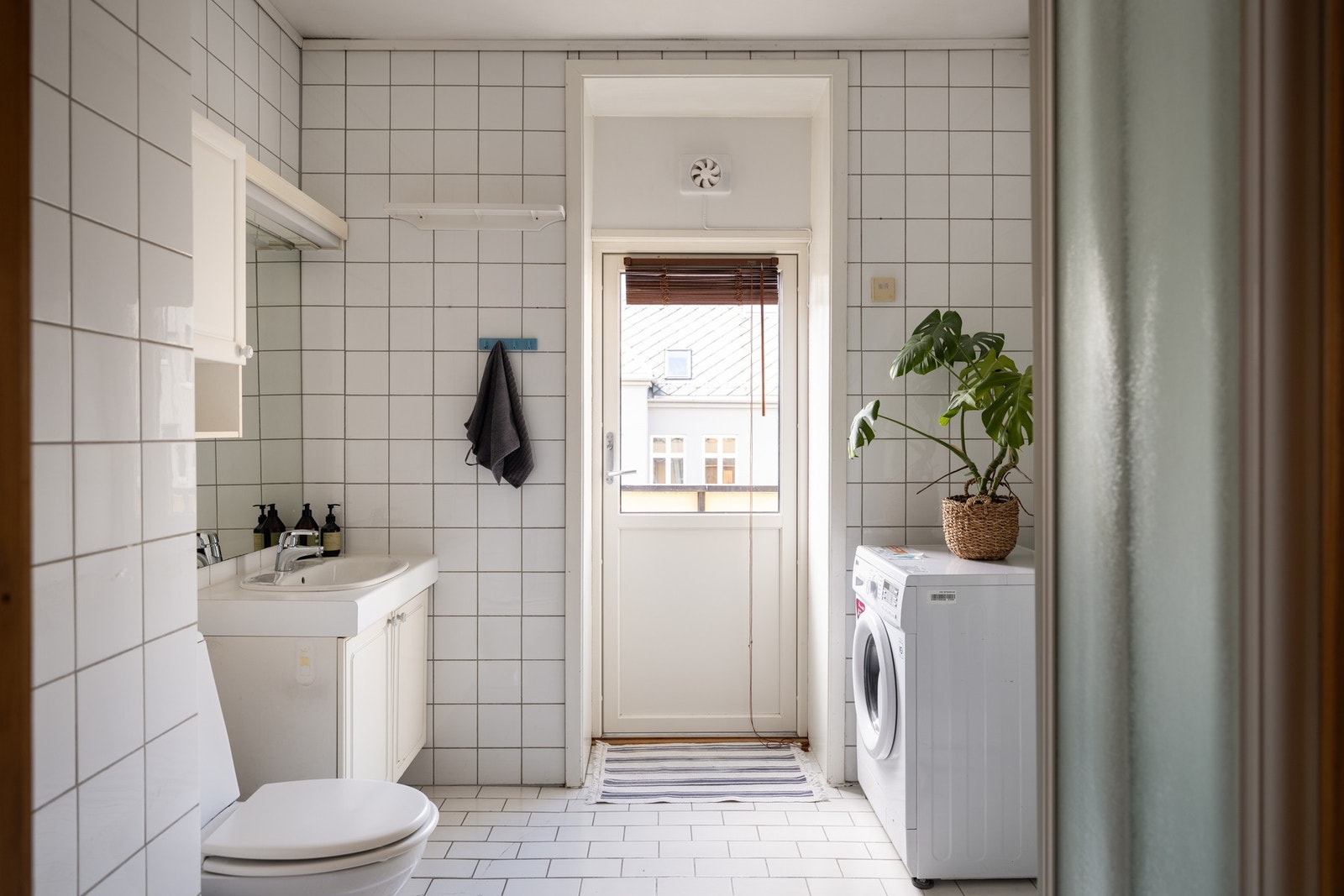 Flislagt baderom med gulvvarme, opplegg for vaskemaskin, dusjkabinett og toalett. Galleribilde