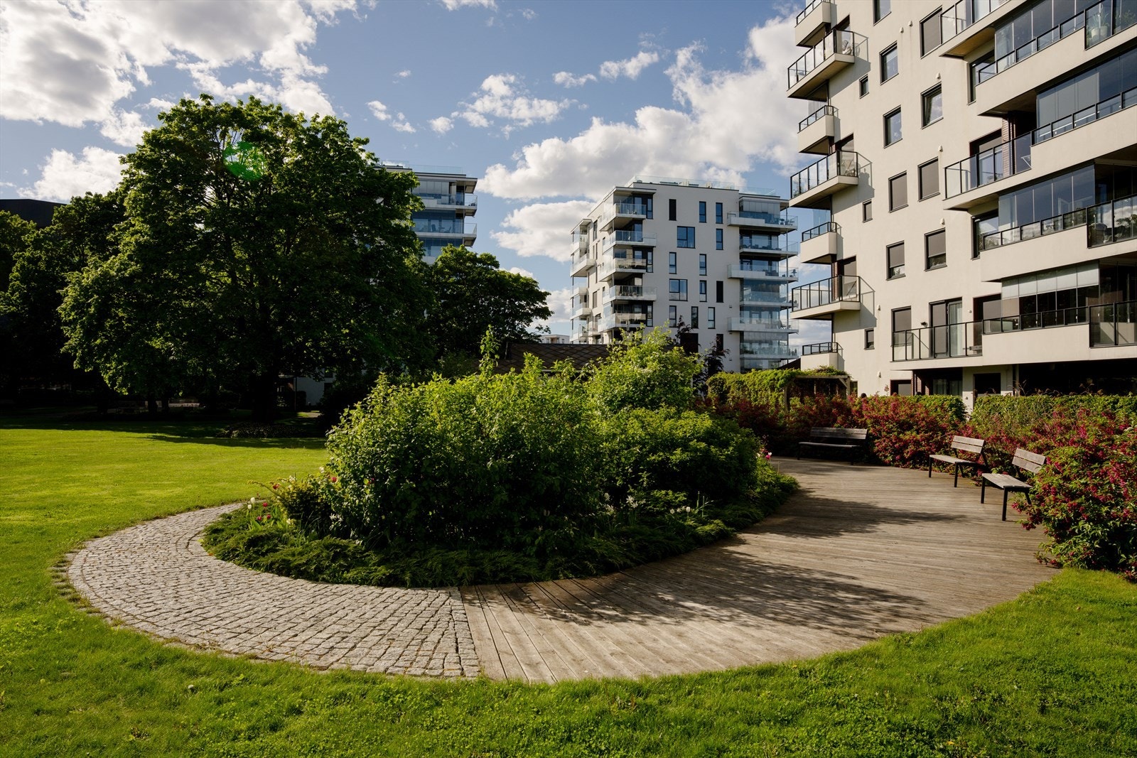 Pent opparbeidede uteområder med sitteplasser og frodig beplantning - et hyggelig sted å være. Galleribilde
