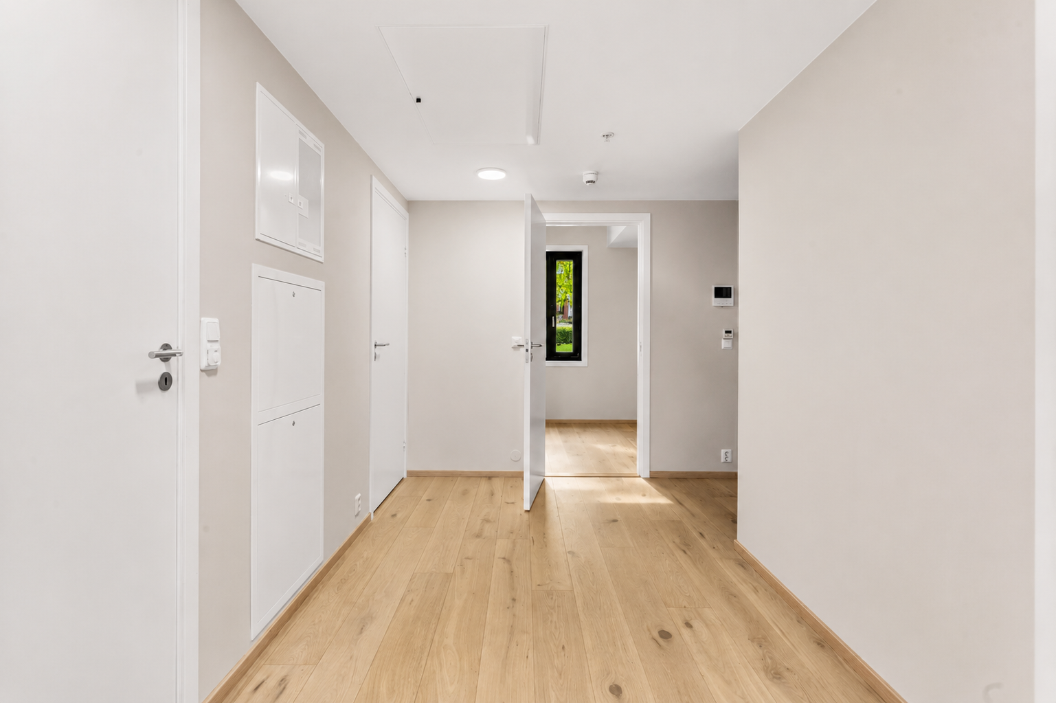 Innbydende entré med 1-stavs eikeparkett på gulv og malte, slette overflater. Her er det god plass til garderobeløsning. Galleribilde