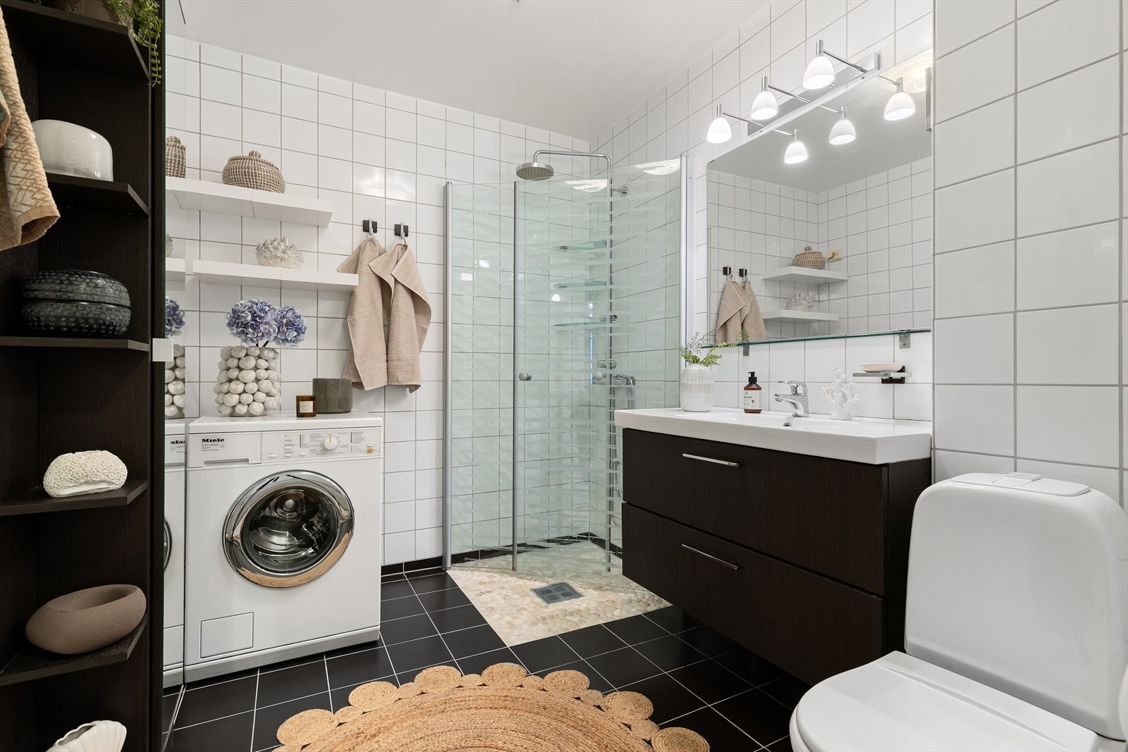 Pent bad med dusjsone, opplegg for vaskemaskin og servantskap med speil Galleribilde