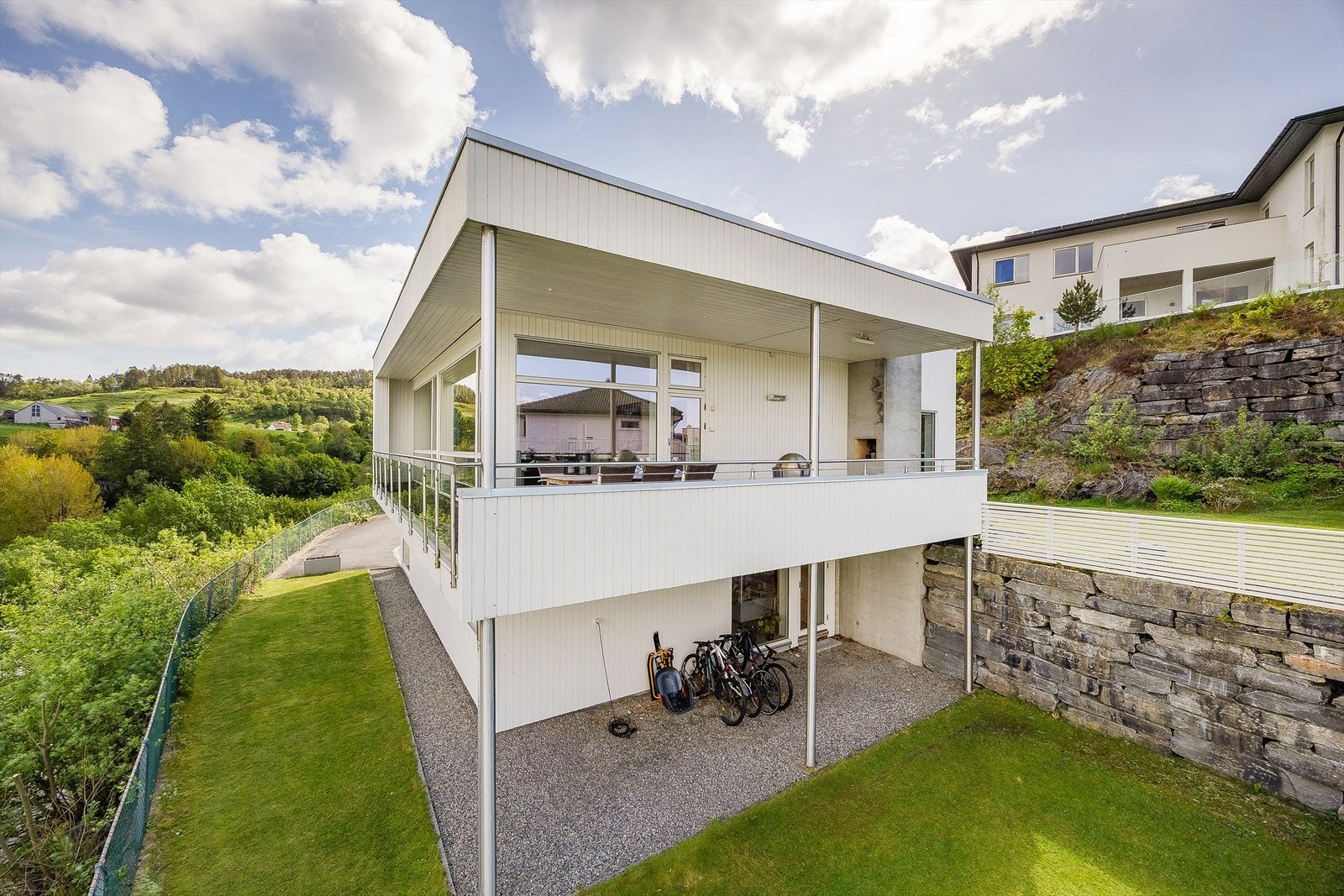 Fra hagesiden ser man den overbygde terrassen og boligens unike arkitektur. Galleribilde
