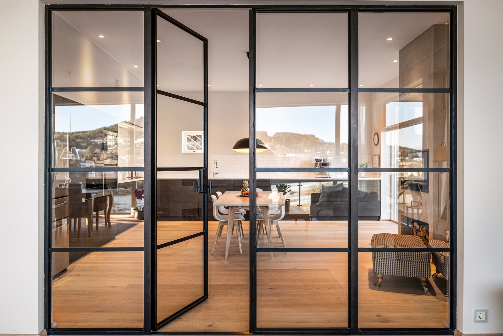 De elegante glassdørene er et sentralt designelement som forbinder rommene. Galleribilde