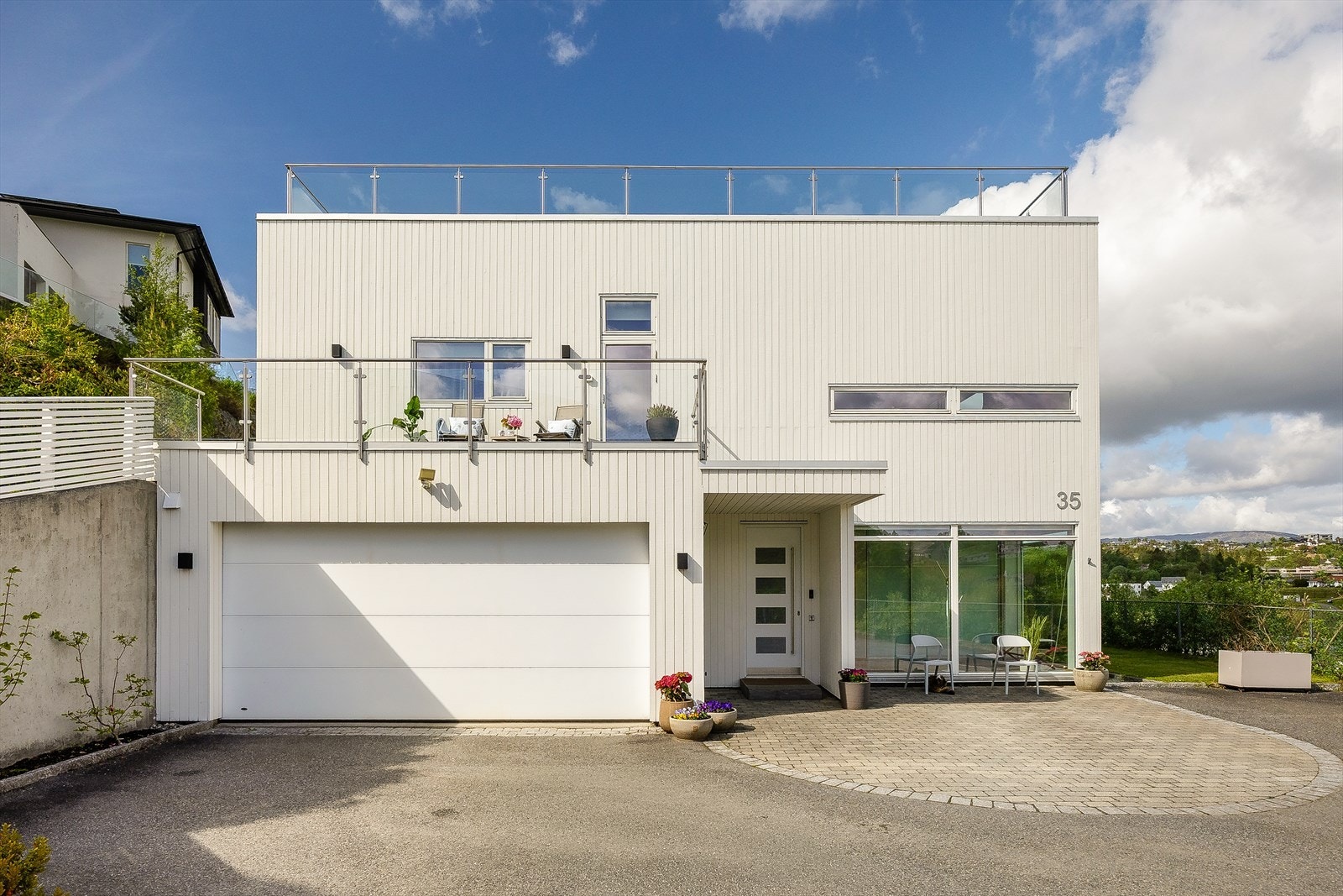 Fasaden er kledd med trepanel, og boligen har en integrert dobbeltgarasje. Galleribilde