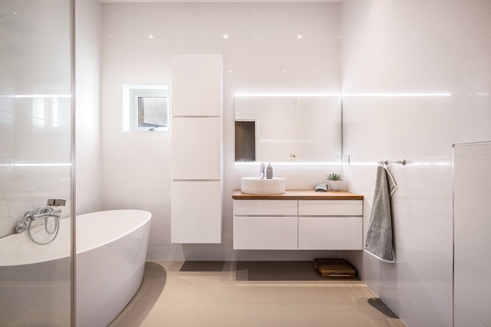 Badet er helfliset og utstyrt med badekar, dusj og vegghengt toalett. Galleribilde