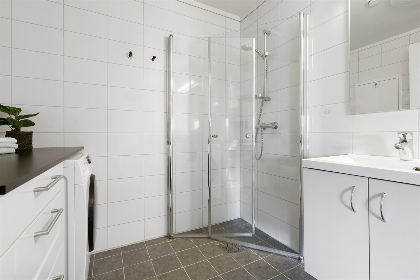 Pent flislagt bad fra 2015 med dusjnisje som har foldbare glassdører samt helstøpt servant. Galleribilde
