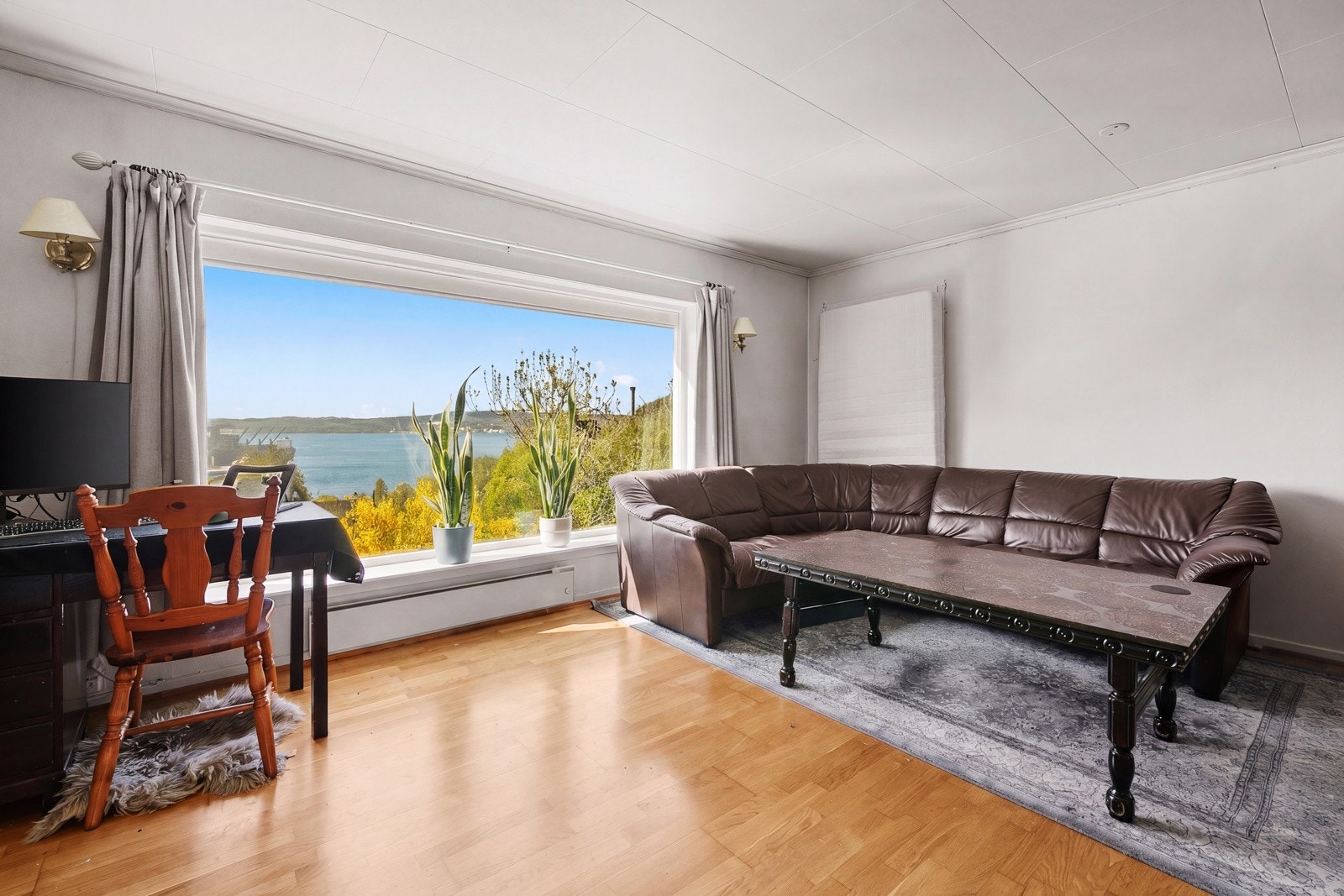 Flott utsikt også fra stuen i leiligheten. Dør ut til terrasse er dekket til. Galleribilde
