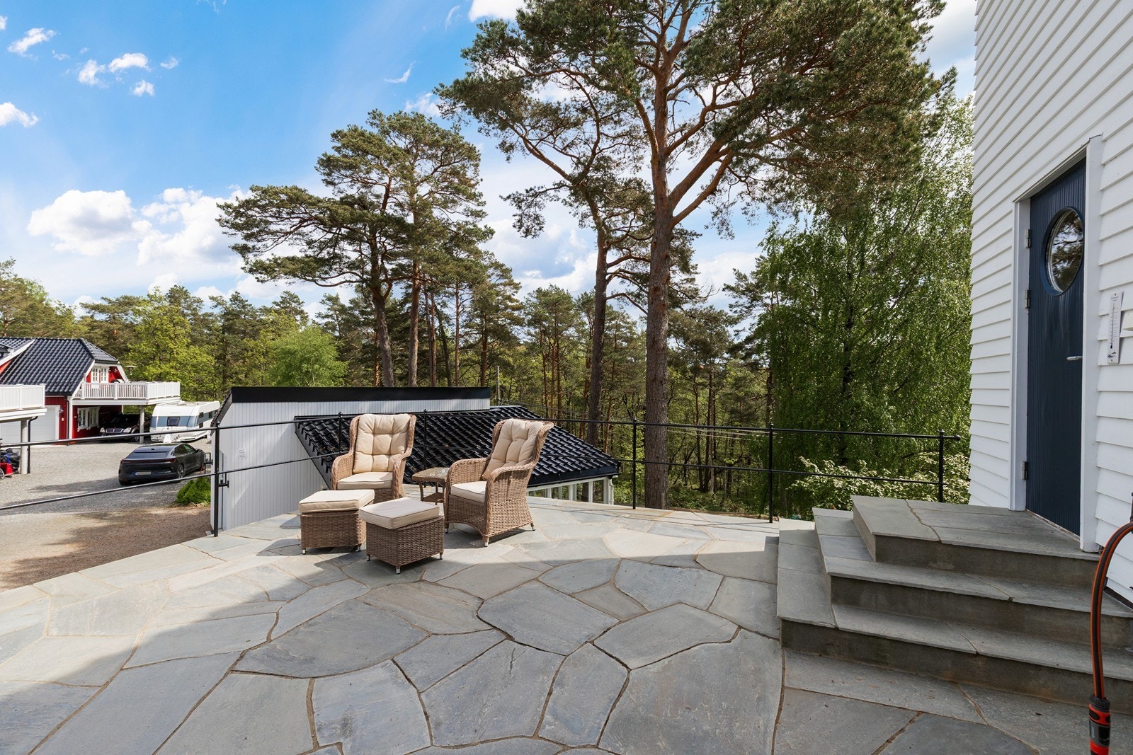 Pent, flislagt terrasse foran inngangspartiet Galleribilde