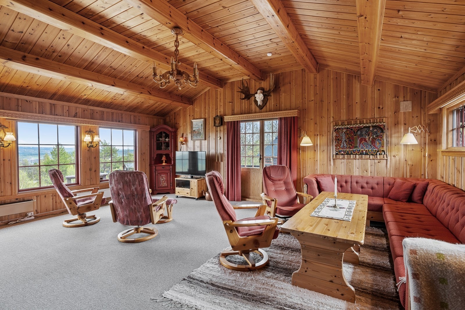 Storslagen stue med høyt til tak, takbjelker i tre og panoramavinduer mot den vakre Rørosdalen. Galleribilde