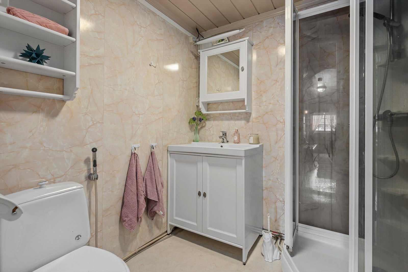 Badet er utstyrt med dusjkabinett, servant og toalett. Tilstandsrapporten anbefaler oppgradering av tettesjikt på sikt. Galleribilde