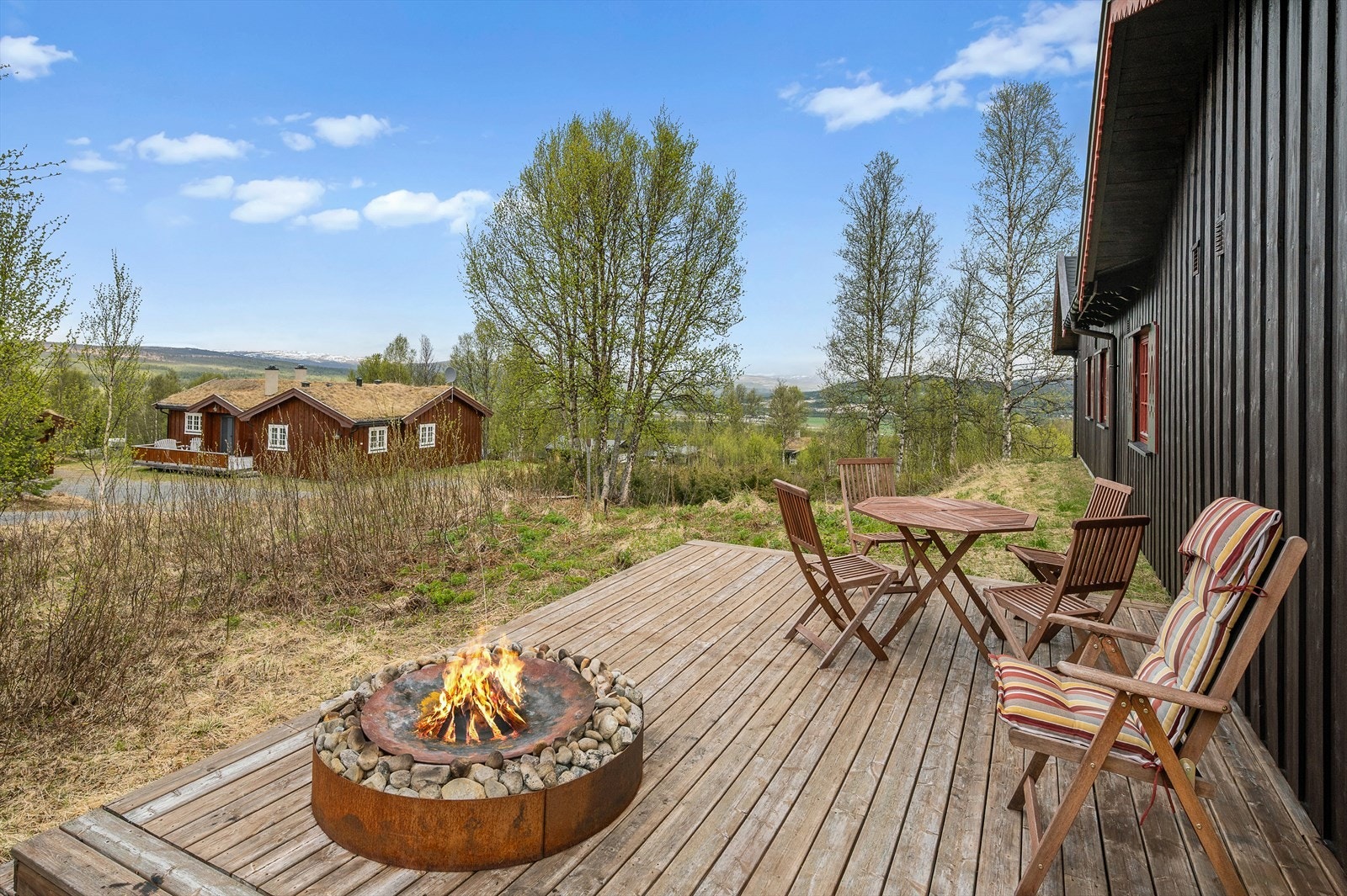 Terrassen vender mot et åpent landskap med utsikt mot fjellene. Et naturlig samlingspunkt for familie og venner. Galleribilde