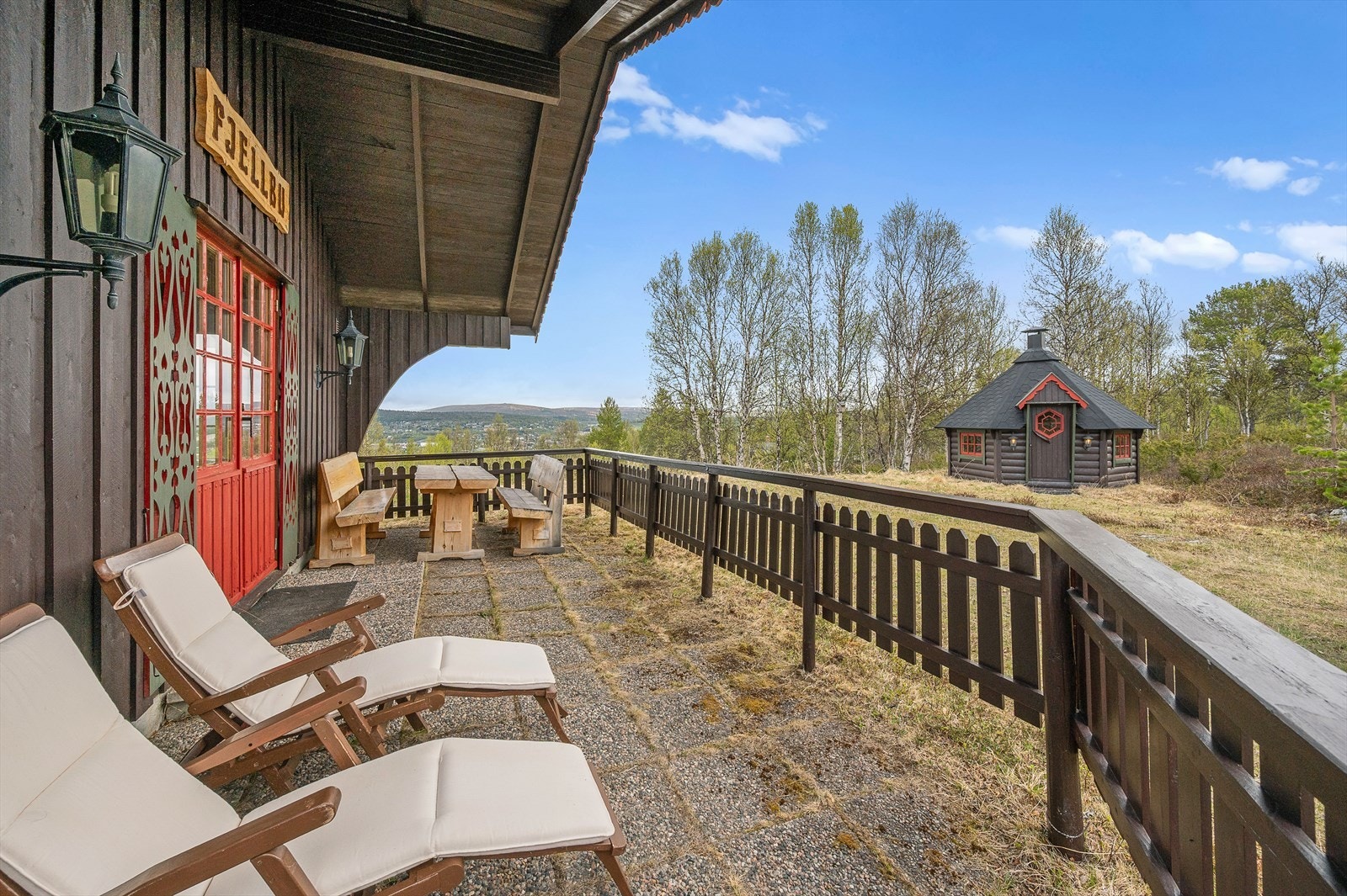 Romslig terrasse med solstoler og grillhytten som nærmeste nabo - tilrettelagt for god trivsel utendørs store deler av året. Galleribilde