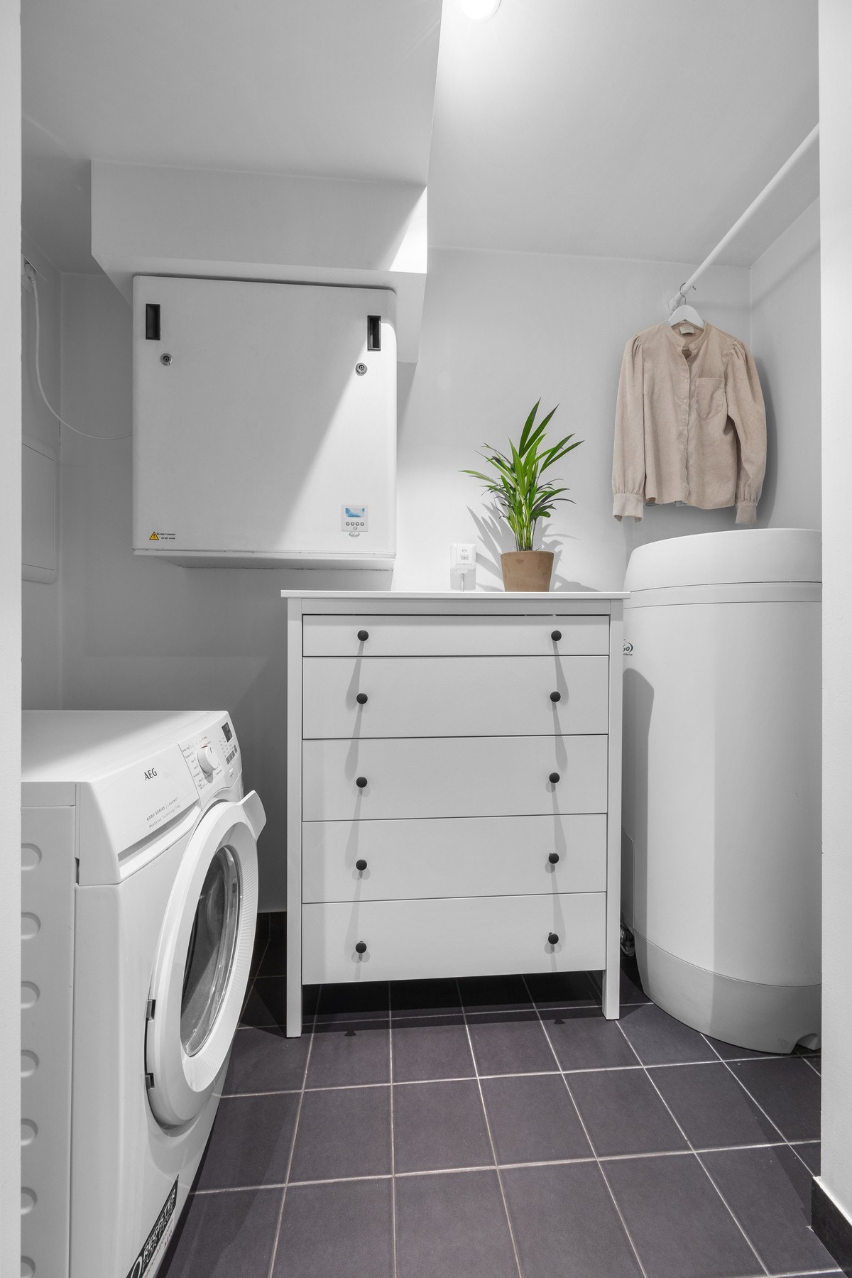 Innenfor badet er det en praktisk vaskesone med opplegg for vaskemaskin. Galleribilde