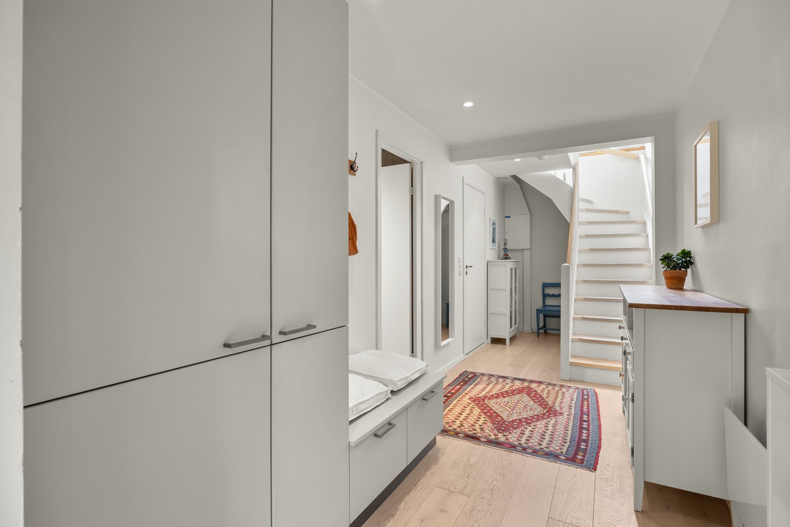 Entréen er romslig og innbydende, og byr på downlights samt gode oppbevaringsmuligheter i praktisk garderobeløsning og under trappen. Galleribilde
