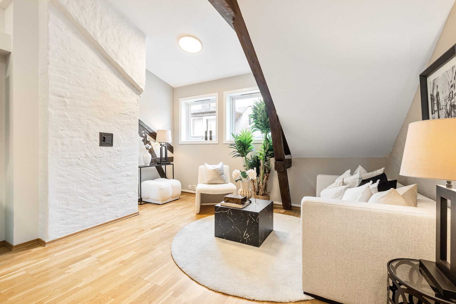 Gjennomgående parkettgulv og malte flater skaper et helhetlig inntrykk. En vegg med murstruktur gir karakter til rommet. Galleribilde