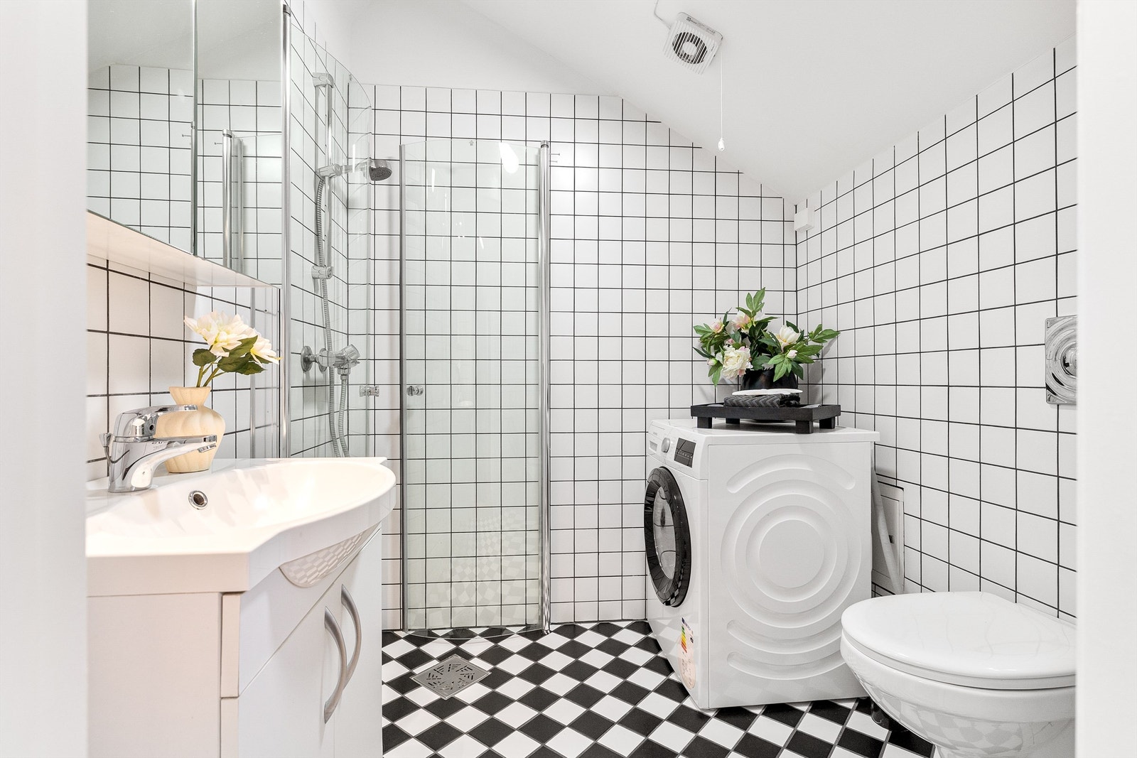 Badet er innredet med dusjhjørne, vegghengt toalett, servant med underskap, speilskap med belysning samt opplegg for vaskemaskin. Foto: Trond Walsø / Walso Work Galleribilde